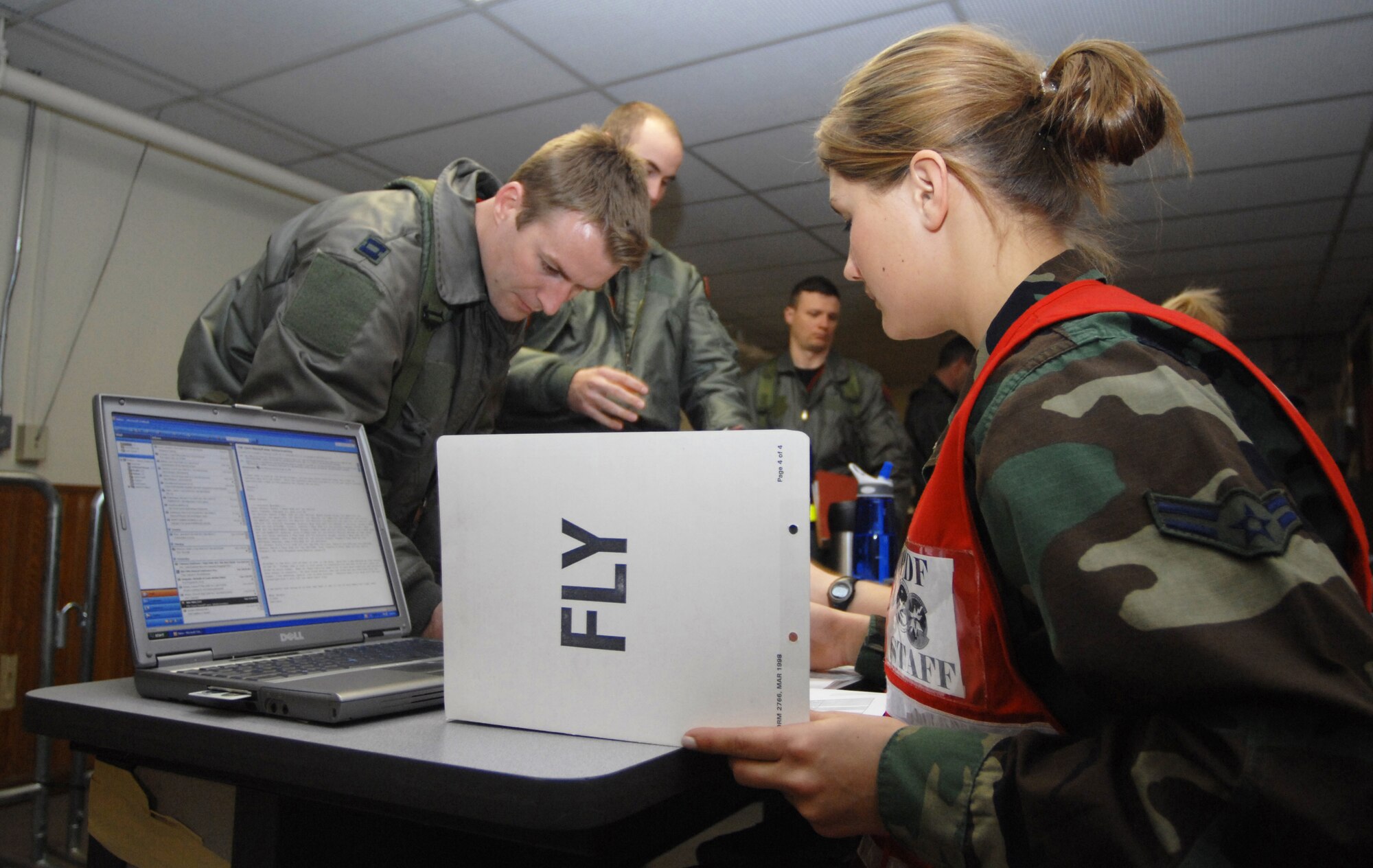 MOUNTAIN HOME AIR FORCE BASE, Idaho - Airman 1st Class Rebecca Banks, 366th Aeromedical Dental Squadron, reviews the mobility folder of Capt. Keith Wooding, 389th Fighter Squadron, as he processes through the personnel deployment function line during Exercise Sharpshooter 08-04.1 Feb. 27. The PDF line is the last stop for personnel who are deploying to get their records and affairs in order. The 366th Fighter Wing conducts exercises to prepare personnel and equipment for the upcoming March 2008 Operational Readiness Inspection. (U.S. Air Force photo/ Airman 1st Class Ryan Crane)