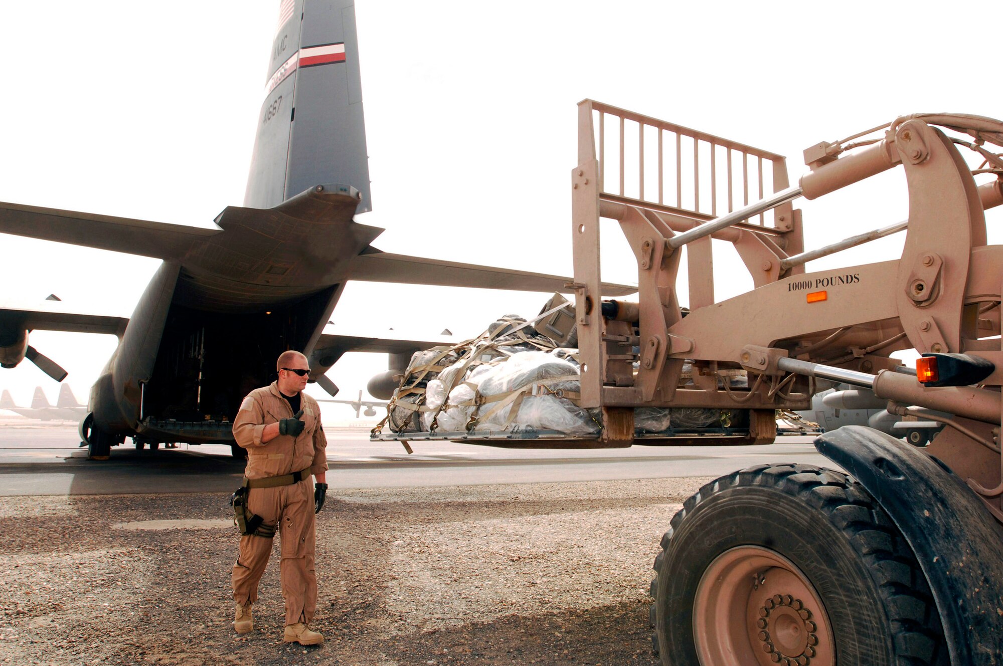 Senior Airman Ian Hunt marshals a 463L cargo pallet onto a C-130 Hercules at an air base in the Persian Gulf Region. The cargo pallet is bound for a base in Iraq. A part of his duties as loadmaster is to ensure cargo is loaded and unloaded in a safe manner and that it's secured to the aircraft, so it doesn't move during flight to bases throughout the theater. Airman Hunt is a C-130 loadmaster deployed with the 737th Expeditionary Airlift Squadron. (U.S. Air Force photo/Staff Sgt. Patrick Dixon)