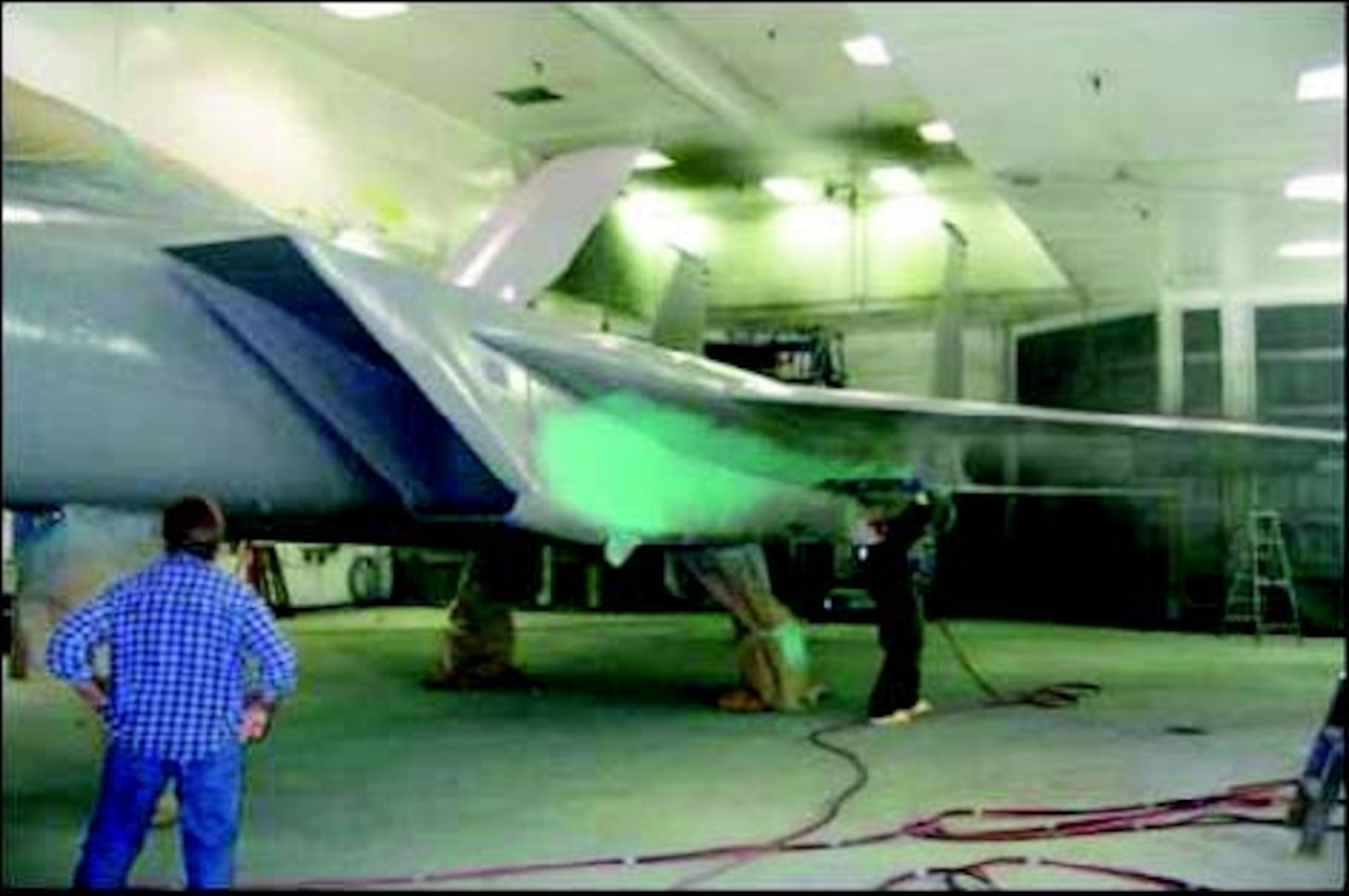 An engineer applies AFRL’s environmentally safe corrosion control coating to a Boeing F-15.