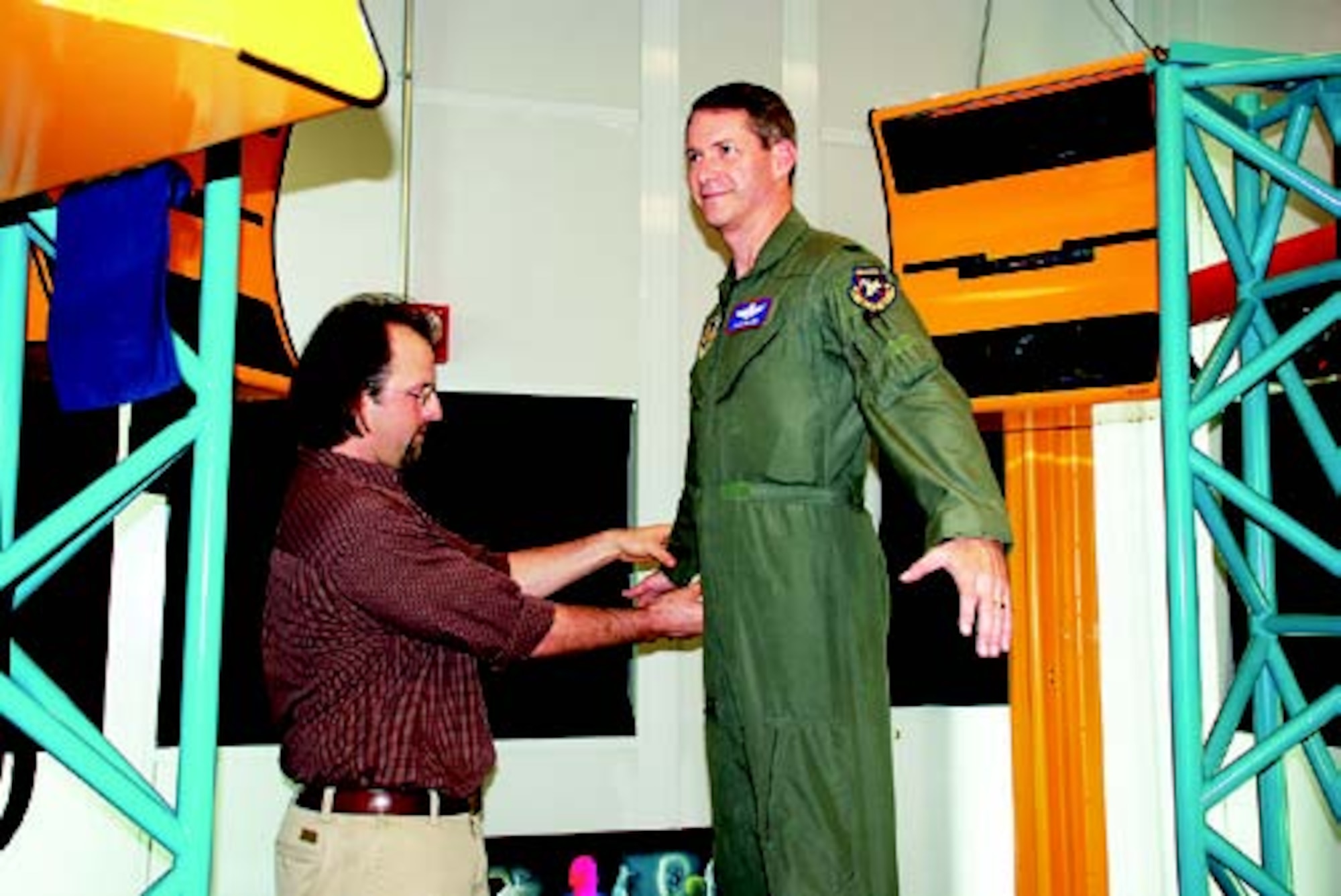 Mr. Scott Fleming (pictured left), anthropologist with AFRL’s Human Effectiveness Directorate, positions AFRL Vice Commander Colonel David B. Glade II in the lab’s three-dimensional whole-body surface scanner as he explains how the body measurement process works (photo by AFRL’s Chris Gulliford).