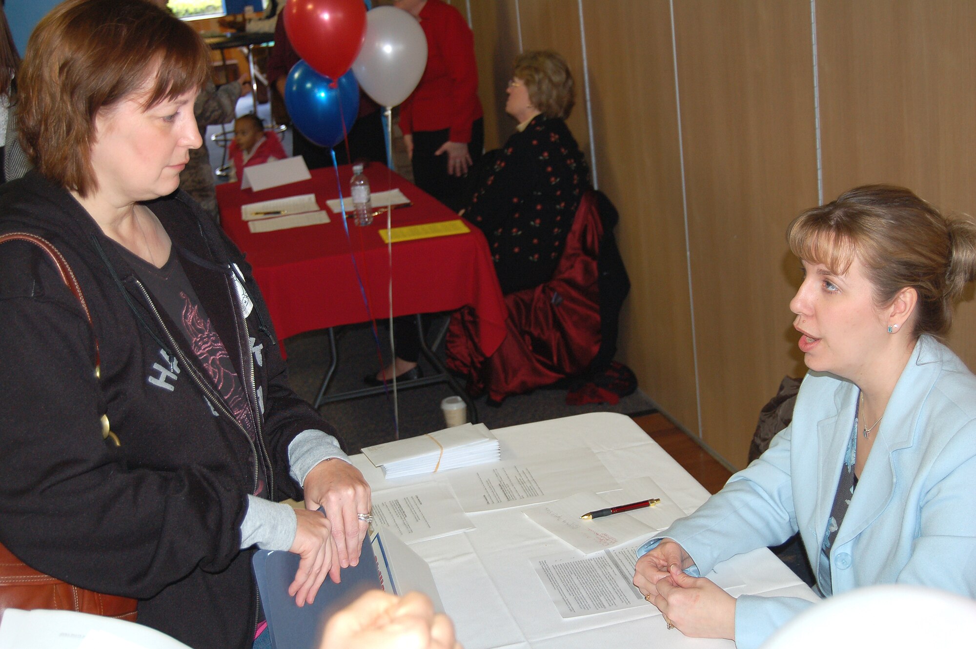 Christy Armstrong (right), 100th Mission Support Squadron human resources specialist, answers questions for a job hunter during an employment fair Feb. 28 at RAF Mildenhall.  The fair provided complete lists of both civil service and non-appropriated fund positions at the base.  There were also step-by-step workshops on the application and hiring process.  (U.S. Air Force photo by Tech. Sgt. Eric Petosky)