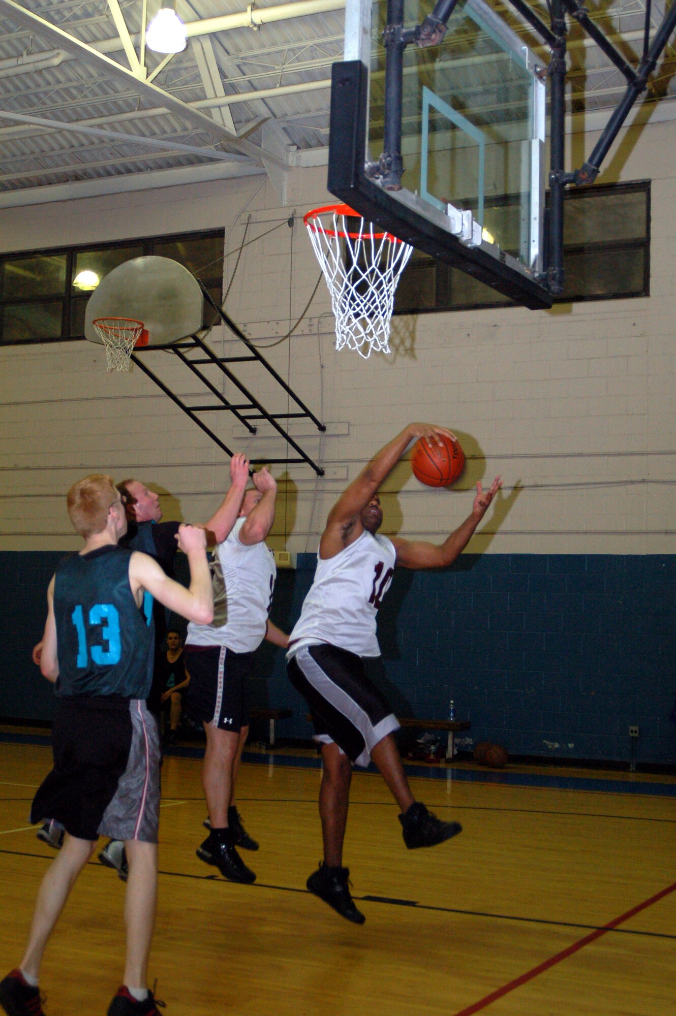 KeAndre Stanton, 436th Communications Squadron, steals the ball from several 736th Aircraft Maintenance Squadron opponents who were attempting to make a basket. The 436th CS won the intramural basketball game against 736th AMXS 36 – 33 at the Fitness Center Feb. 25. (U.S. Air Force photo/ Airman 1st Class Shen-Chia Chu)