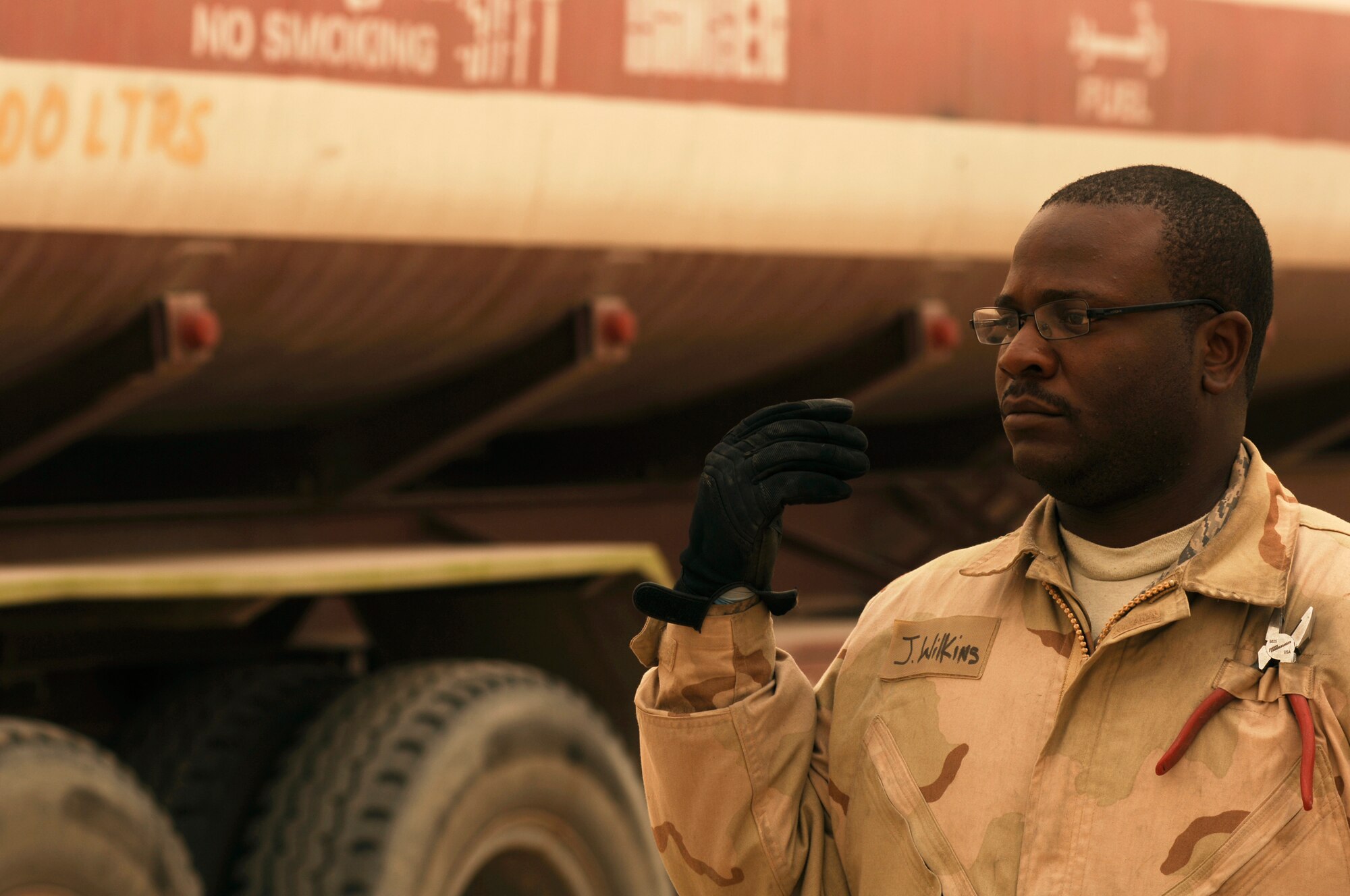 SOUTHWEST ASIA -- Staff Sgt. Jerome Wilkins, a fuels technician from the 386th Expeditionary Logistics Readiness Squadron, motions forward another fuel truck to have its fuel downloaded into a bladder storage unit at an air base in the Persian Gulf Region Feb. 26, 2008. The fuels management flight is responsible for inventorying the fuel daily, and the transfer and issue of fuel to both vehicle operators and aircrews in support of Operations Enduring and Iraqi Freedom. (U.S. Air Force photo/ Staff Sgt. Patrick Dixon)