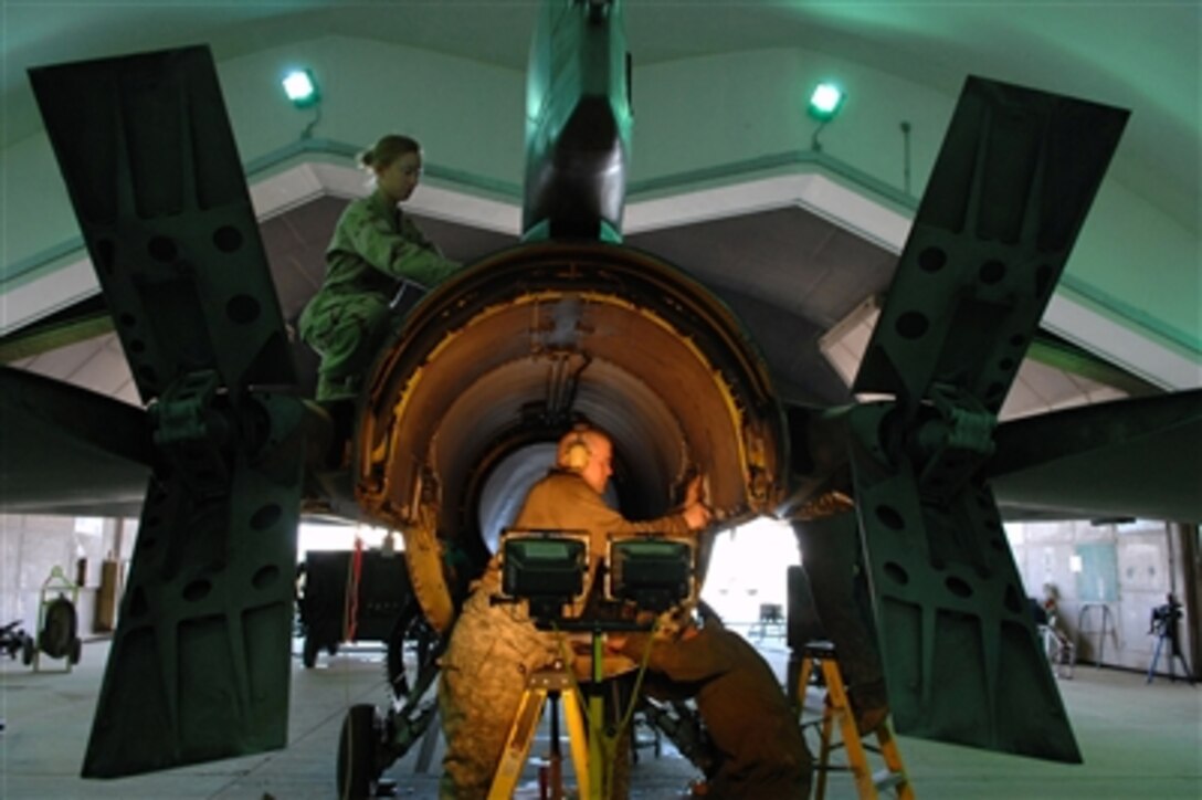 U.S. Air Force Senior Airman Rebeca Hill (top) and Senior Airman Christopher Jaeger conduct maintenance on an F-16 Fighting Falcon aircraft at Balad Air Base, Iraq, on Feb. 21, 2008.   F-16 aircraft go through overhaul maintenance every 300 hours to ensure all components are in top condition.  Hill is a non-destructive inspection technician and Jaeger is a crew chief with the 332nd Expeditionary Maintenance Squadron.  