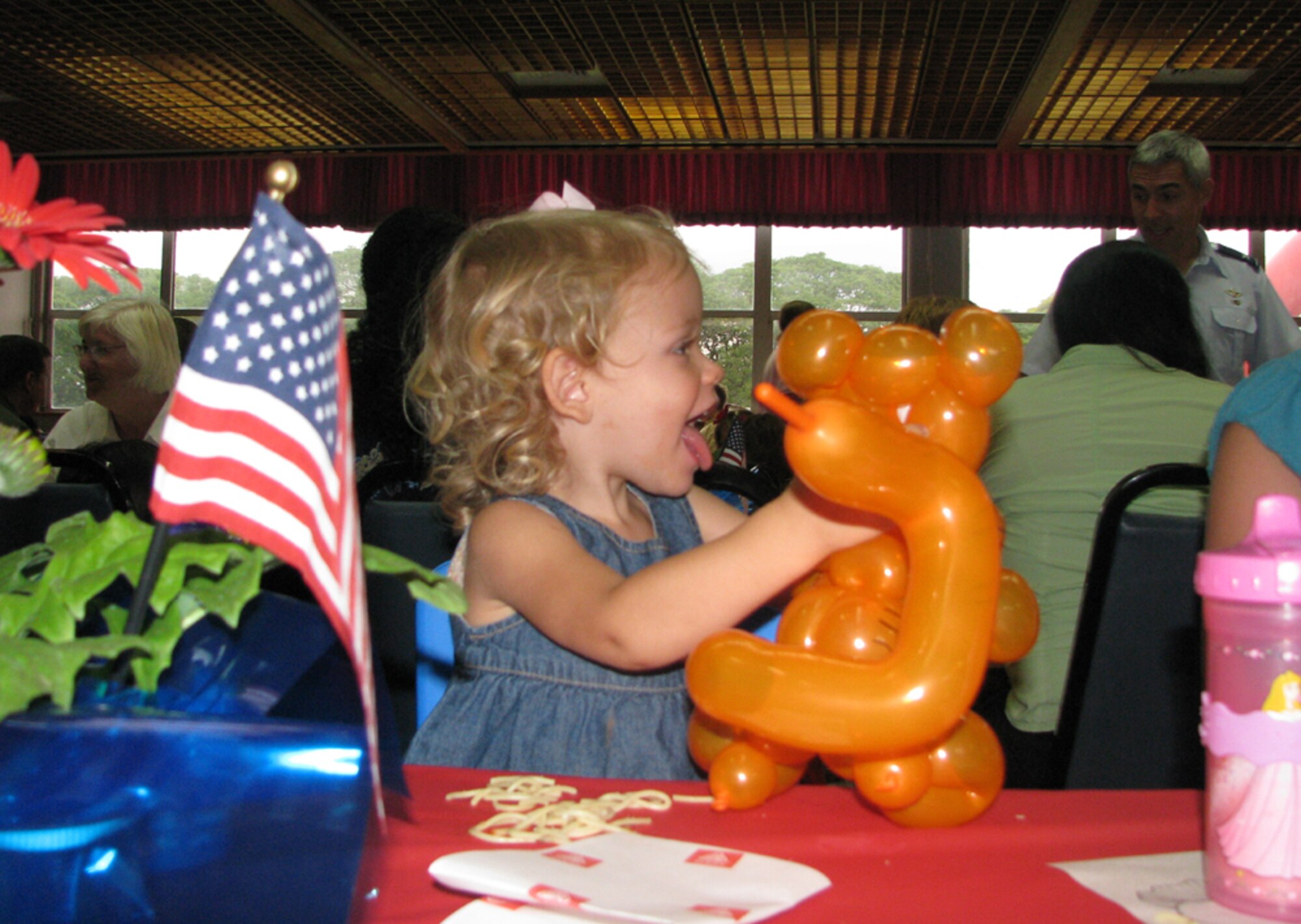 Carsen (daughter of Capt Colaw/15 AW/JA) enjoys her balloon animal that was presented by Balloon Monsoon staff during the deploye/remote-family dinner activity.  