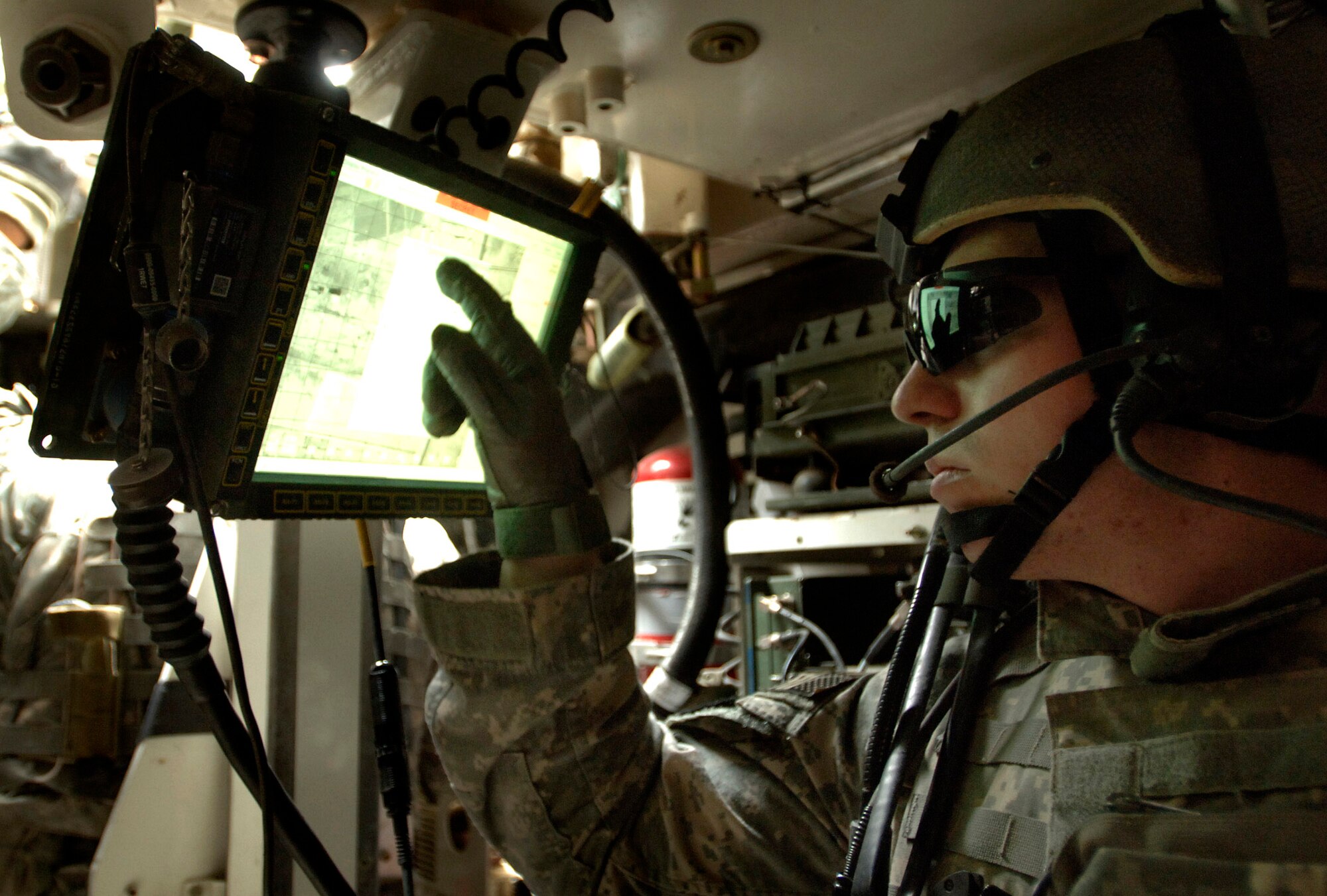 Staff Sgt. Daniel Strom punches in coordinates inside a Stryker assault vehicle to verify his position during a recent deployment. Sergeant Strom was embedded with Army forces to communicate coordinates for close-air support during fire fights with enemy ground forces.