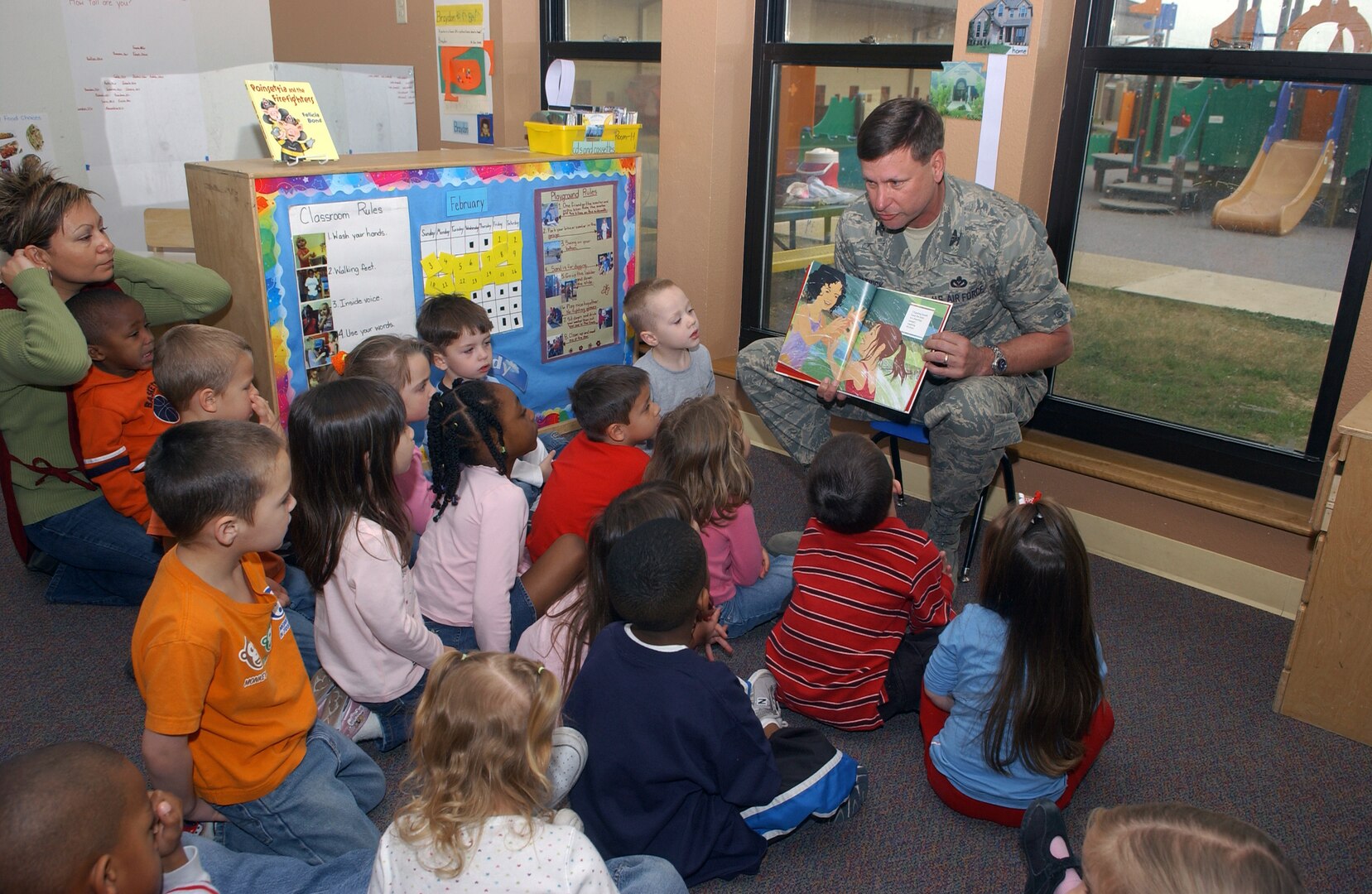 Brig. Gen. Len Patrick, 37th Training Wing commander, reads the book "Hands!" to a group of children at the Lackland Child Development Center on Feb. 19. The event was sponsored by the African American Heritage Committee. (USAF photo by Alan Boedeker)                            