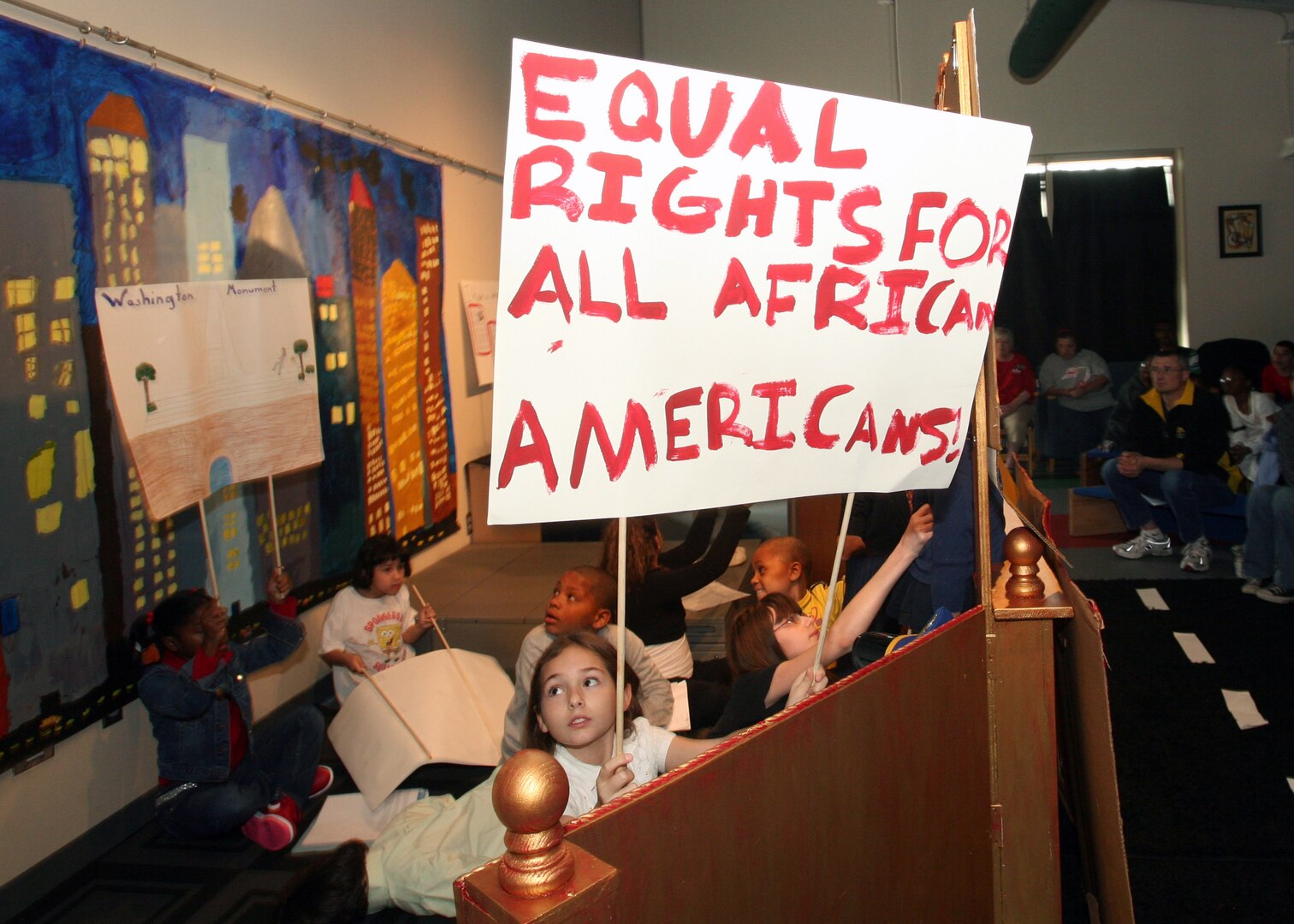 A group of children holds up signs supporting racial equality during the Lackland Youth Center's annual African American Heritage program Feb. 23 at Lackland Air Force Base, Texas. The event included wagon rides and displays from Buffalo Soldier representatives, as well as jazz and poetry tributes. (USAF photo by Robbin Cresswell)