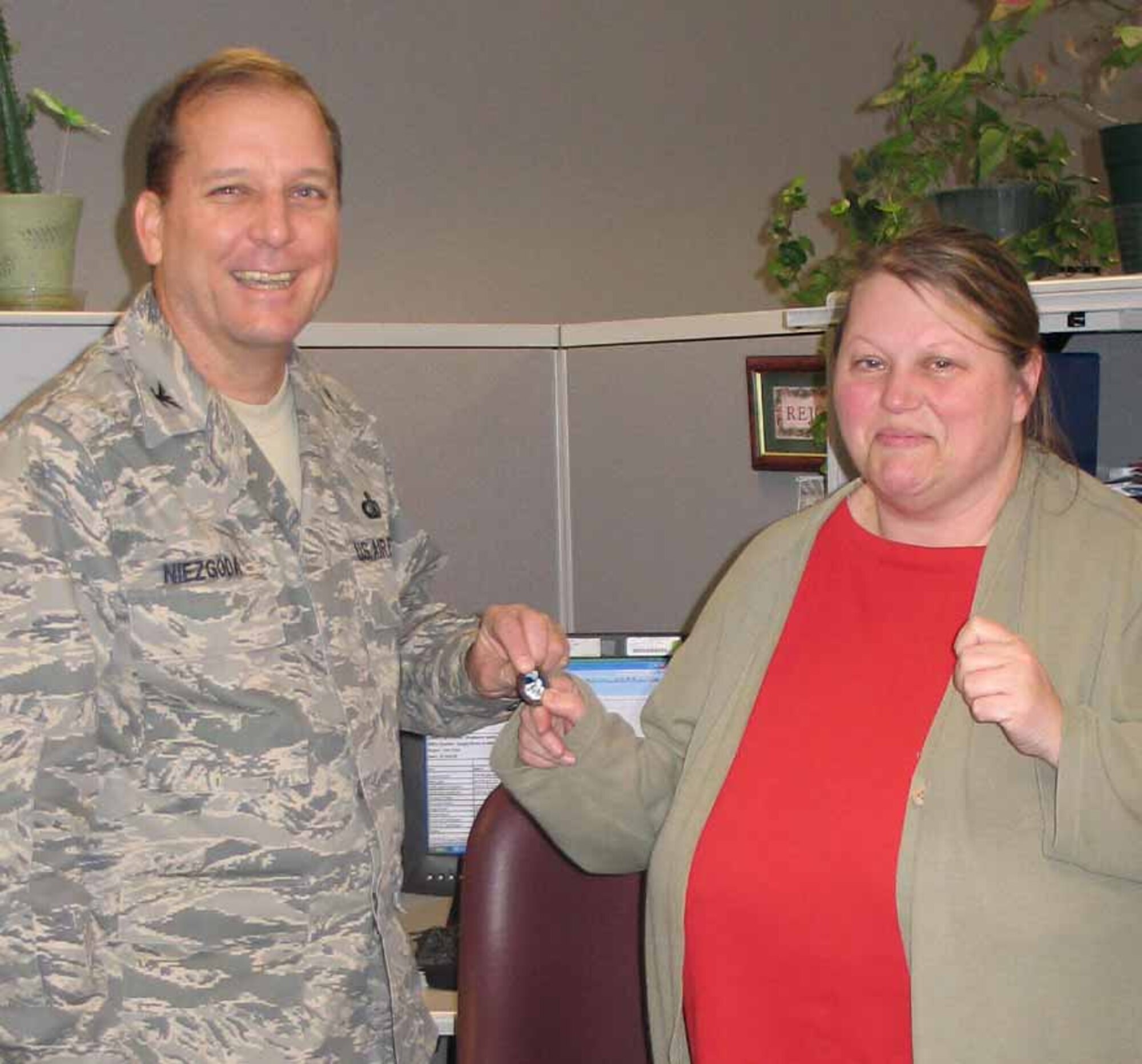 Col. Michael Niezgoda, 38th Engineering Installation Group commander, presents a Wingman coin to Stephanie Smith, communications clerk.  (Air Force photo by Vicki O'Pecko)