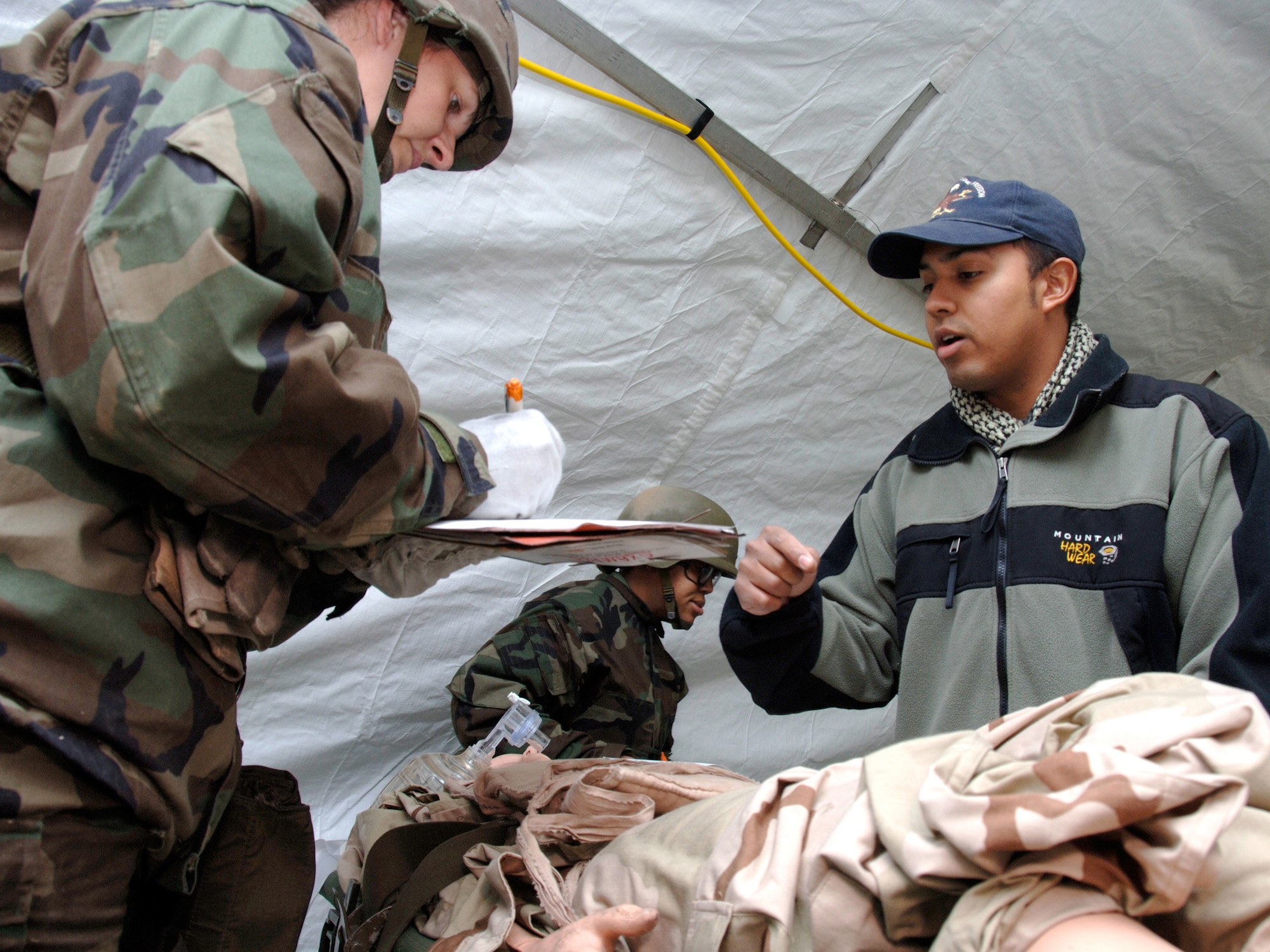 Medical Readiness Training instructor George Torres (right) discusses transport options with Tech. Sgt. Erin Wooden (left) during an exercise held as part of the medical readiness training course conducted by the 59th Medical Logistics and Readiness Squadron. The course is designed to help medical personnel prepare for deployments. Sergeant Wooden is a 59th Clinical Support Squadron member. (U.S. Air Force photo/Master Sgt. Kimberly Yearyean-Siers) 