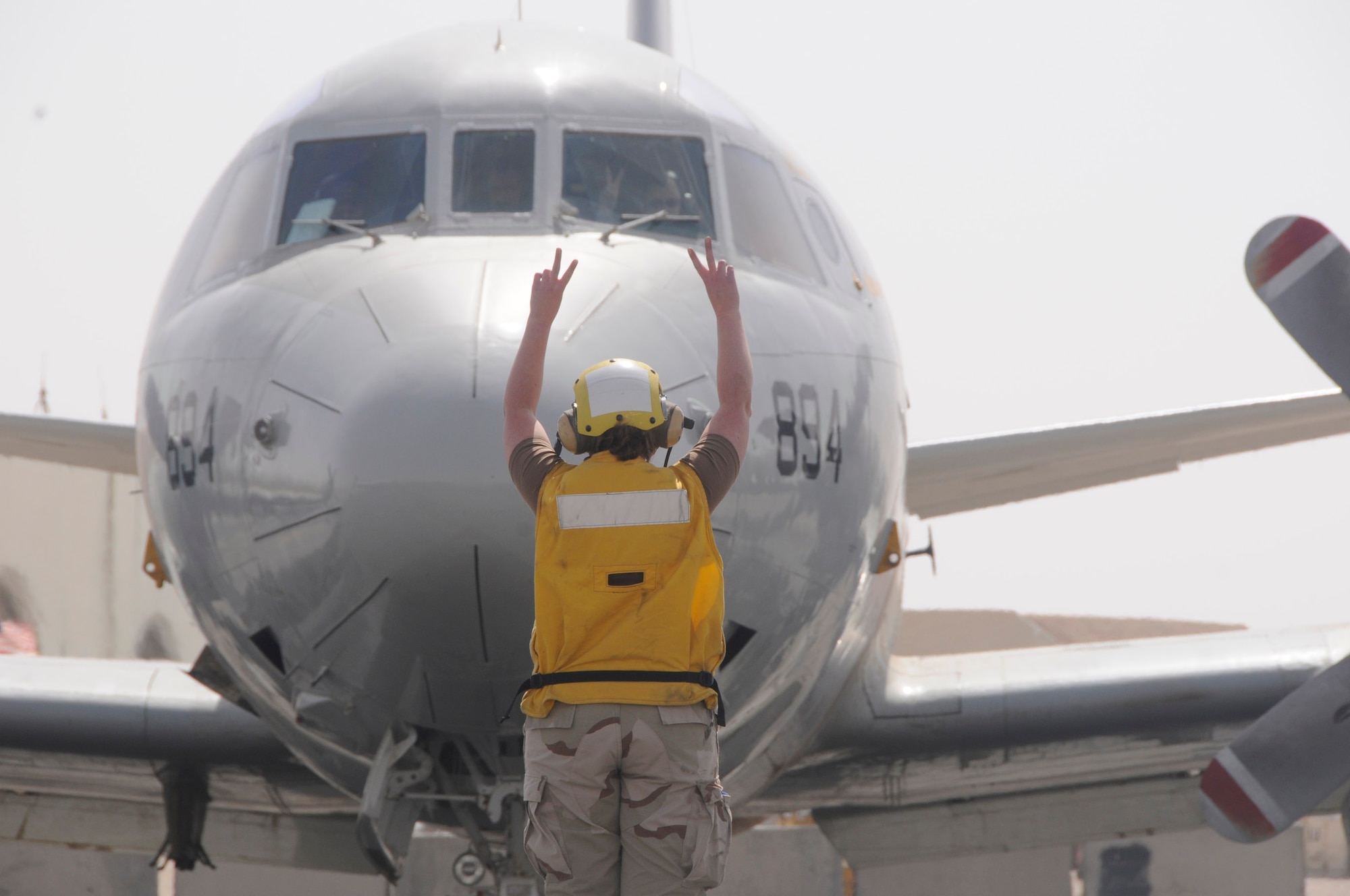A Navy VP-26 Patrol Squadron member signals the aircrew prior to take-off Feb. 26 from an air base in Southwest Asia. Navy members are stationed on the air base in support of battlespace surveillance missions. (U.S. Air Force photo/Senior Airman Domonique Simmons) 