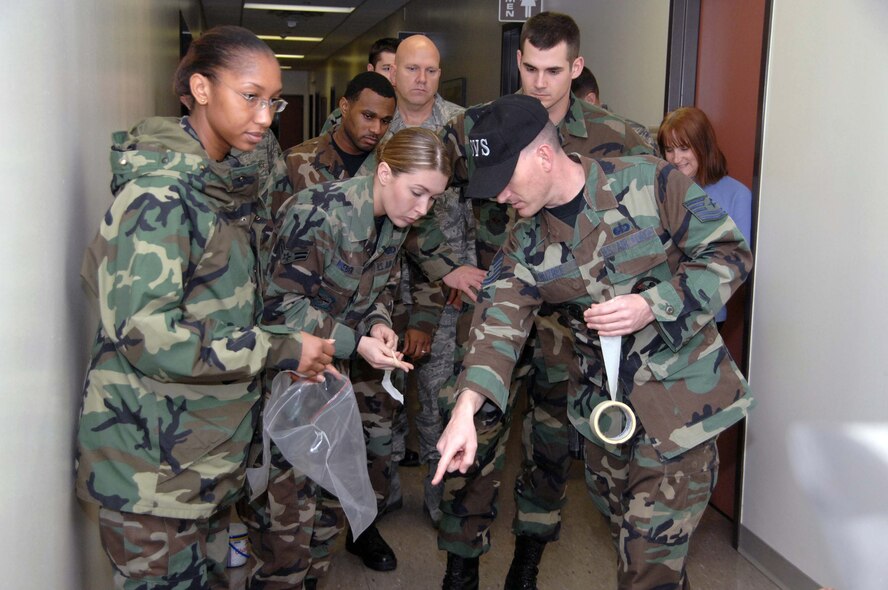 Tech. Sgt. Kaema DeSouza, (front left), Airman 1st Class Sara Weber and Tech. Sgt. Mark Buzbee, all of the 60th Services Squadron, sweep an incident site and record the placement of remains during the Home Station Attack Response Exercise Feb. 21. The group is part of the Travis Search and Recovery Team. (U.S. Air Force photo/Nan Wylie)