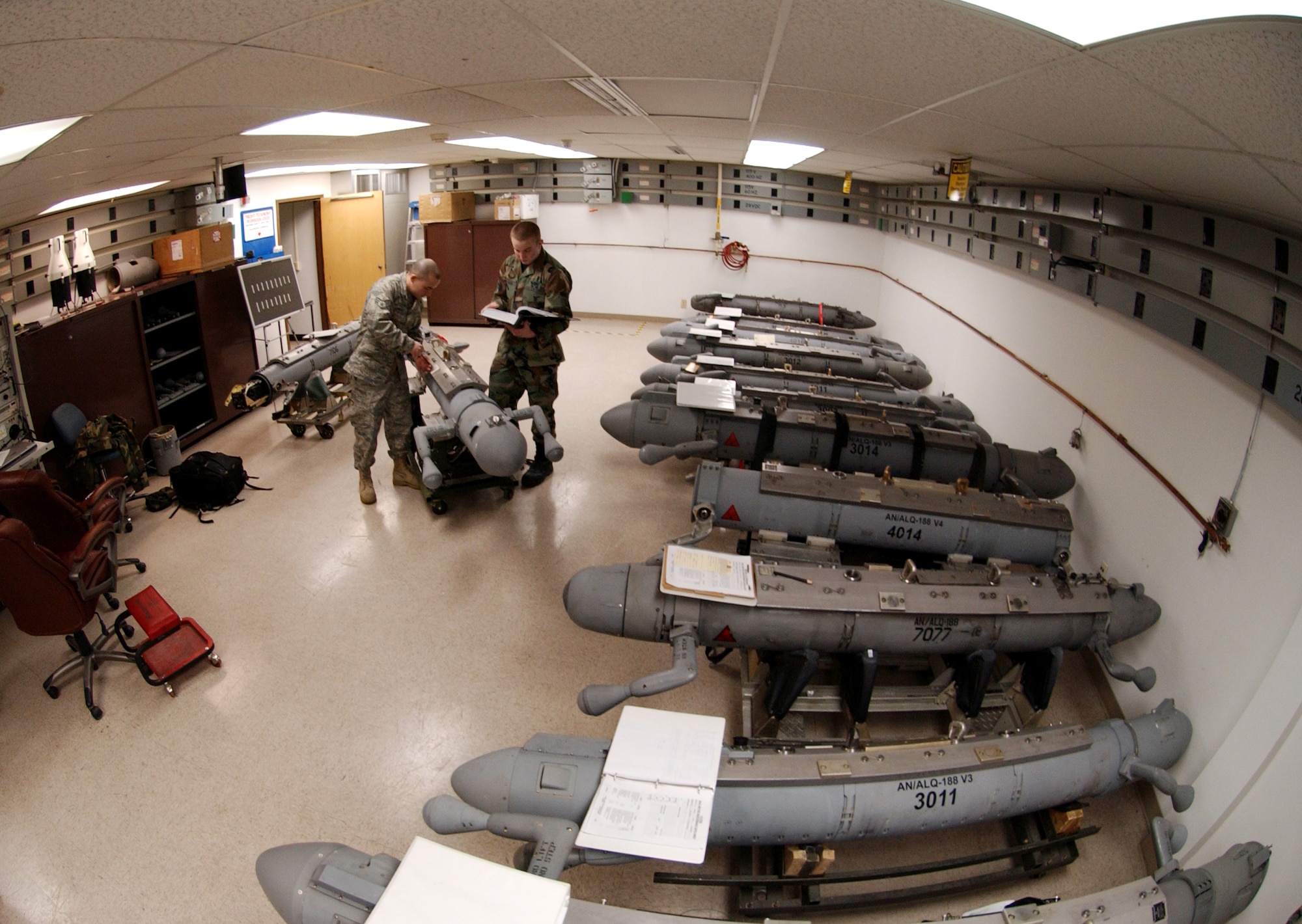 EIELSON AIR FORCE BASE, Alaska -- Senior Airman Frank Canfield assists Airman 1st Class Timothy Ogburn in replacing safety wire on a 188 Electronic Attack Pod V-ban Feb. 27 2008 at the avionics flight building. The pods, maintained by the avionics flight for Alaska's harsh arctic winters, provide an offensive electronic attack that degrades an enemy aircraft's radar. Airman Canfield is an avionics sensors journeyman. Airman Ogburn is an electronic warfare journeyman. Both are assigned to the 354th Maintenance Squadron here.  (U.S. Air Force photo by Airman 1st Class Christopher Griffin) 