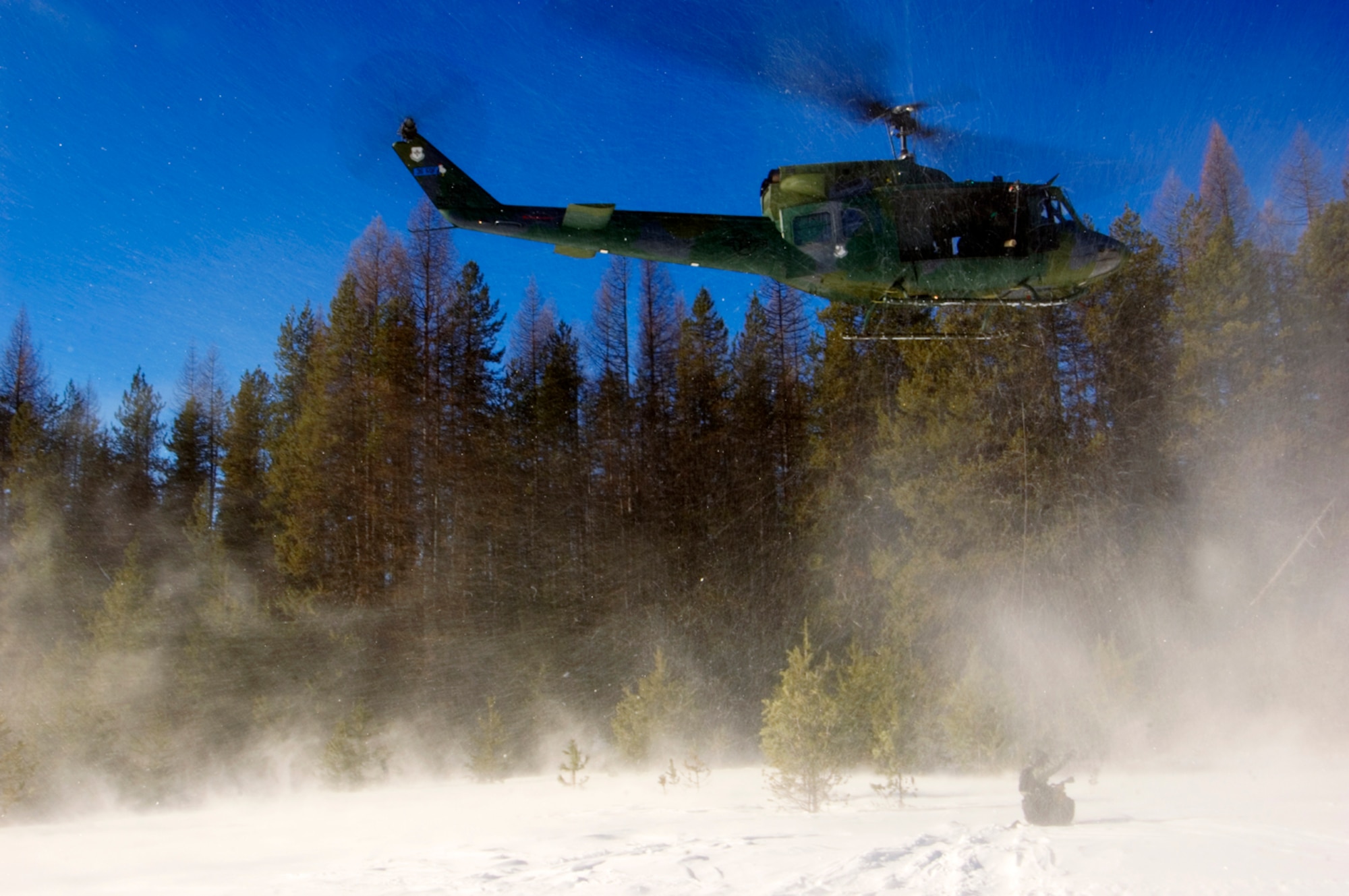 Armed with 250-foot rescue hoists, the 36th Rescue Flights UH-1 Huey helicopters are ideal vehicles to extract injured and/or stranded victims off of rooftops, mountaintops or just about anywhere else you can think of because they don't have to land. (Air Force photo by Tech. Sgt. Matthew Hannen)