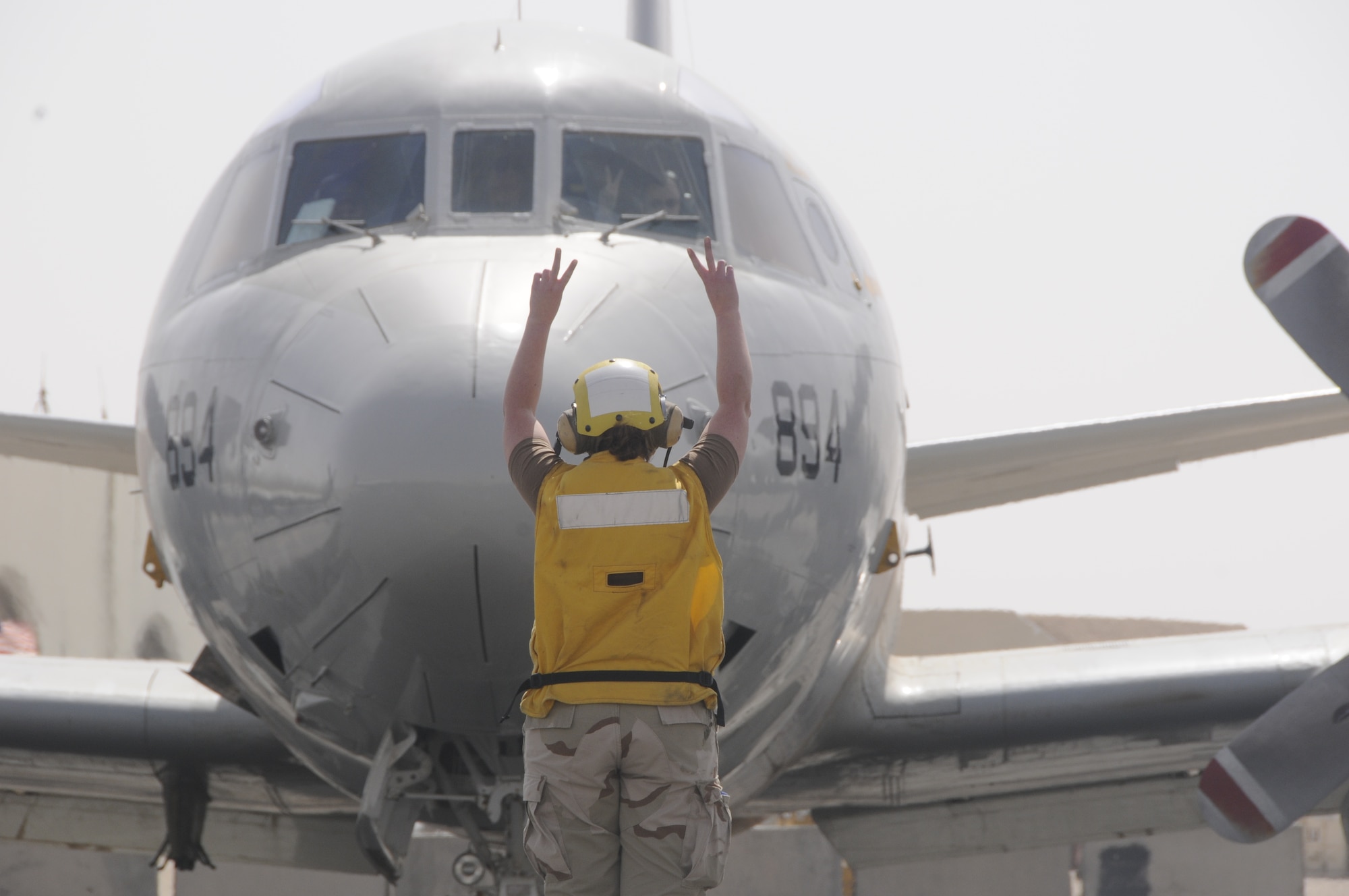 A Navy VP-26 Patrol Squadron member signals the crew prior to take-off Feb. 26. (U.S. Air Force photo/Senior Airman Domonique Simmons)