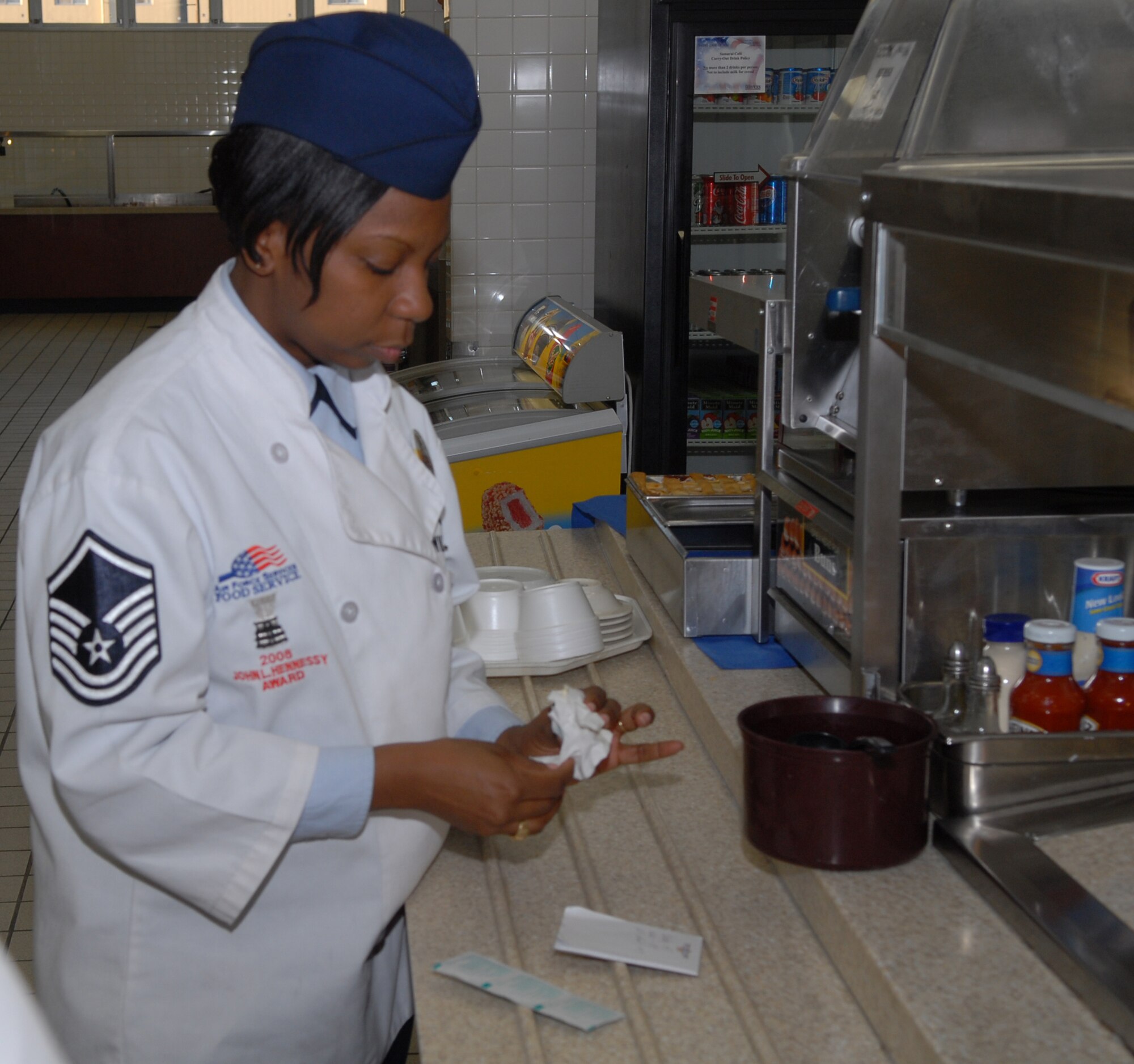 Master Sgt. Michelle Williams, Head Quarters Air Force Services Agency Hennesy Award Judge, inspects to make sure that items on the serving are are sanitized at the Samuria Cafe here Feb. 28. The Hennesy team goes to different dinning facilities through out the Pacific Air Force and inspects and judges of variety of items for the Hennesy Award.