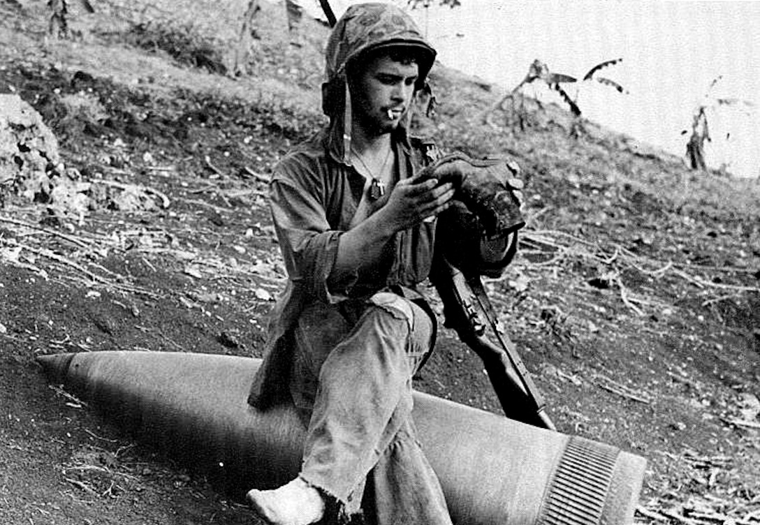 Classic photo of U.S. soldier pausing for a break while sitting on an unexploded 16 inch naval shell, at Saipan 1944.

From: Breaching The Marianas: The Battle For Saipan. Marines In World War II Commemorative Series. By Captain John C. Chapin, U.S. Marine Corps Reserve (Ret.). Published by History and Museums Division, Headquarters, U.S. Marine Corps, Washington, D.C. as part of the U.S. Department of Defense observance of the 50th anniversary of victory in that war. 
