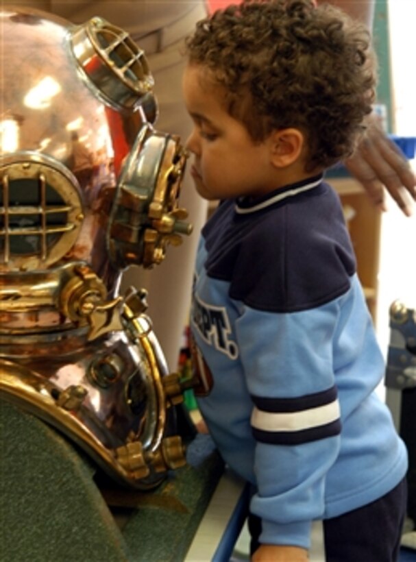 A young boy in the voluntary pre-kindergarten classes at the Naval Station Child Development Center in Mayport, Fla., inspects the diving helmet used in previous years by Navy divers, Feb. 27, 2008. 