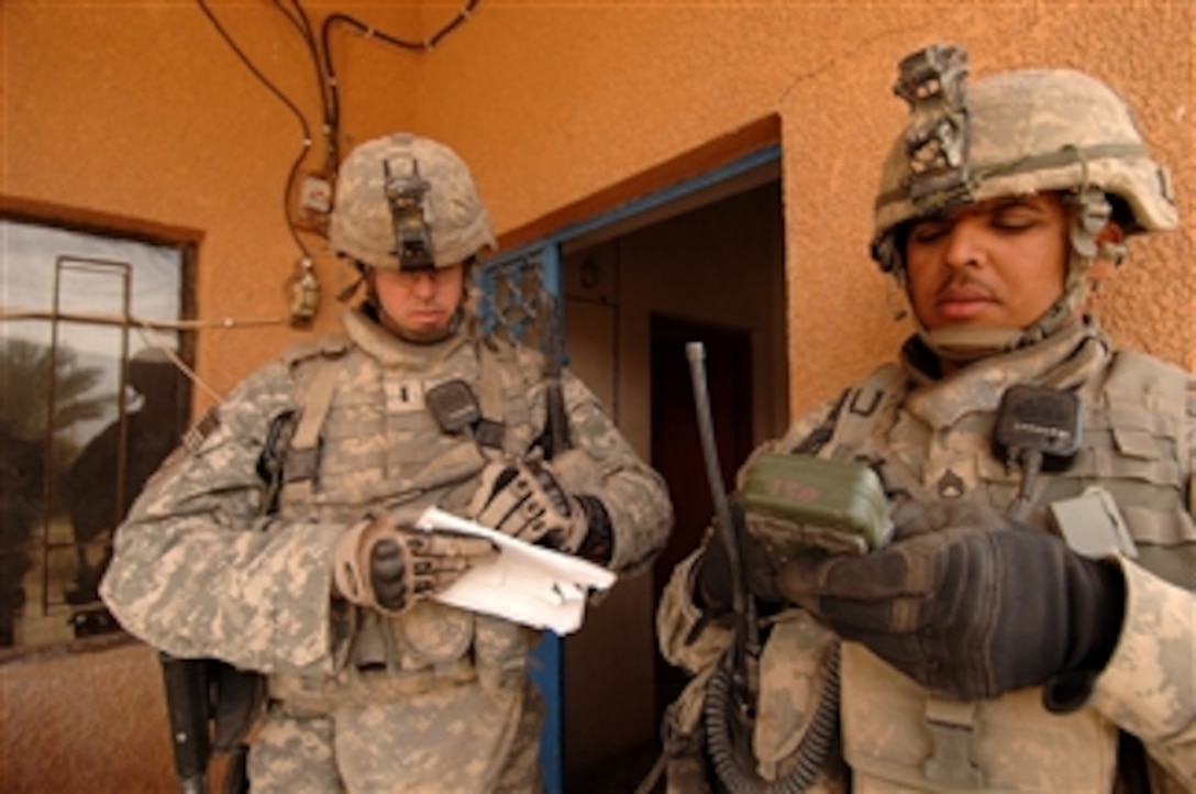 U.S. Army 1st Lt. Josh Jones (left) from Bravo Company, 1st Battalion, 15th Infantry Regiment, 3rd Heavy Brigade Combat Team, 3rd Infantry Division receives a grid coordinate from a fellow soldier during a clearing operation in Kesra, Iraq, on Feb. 24, 2008.  