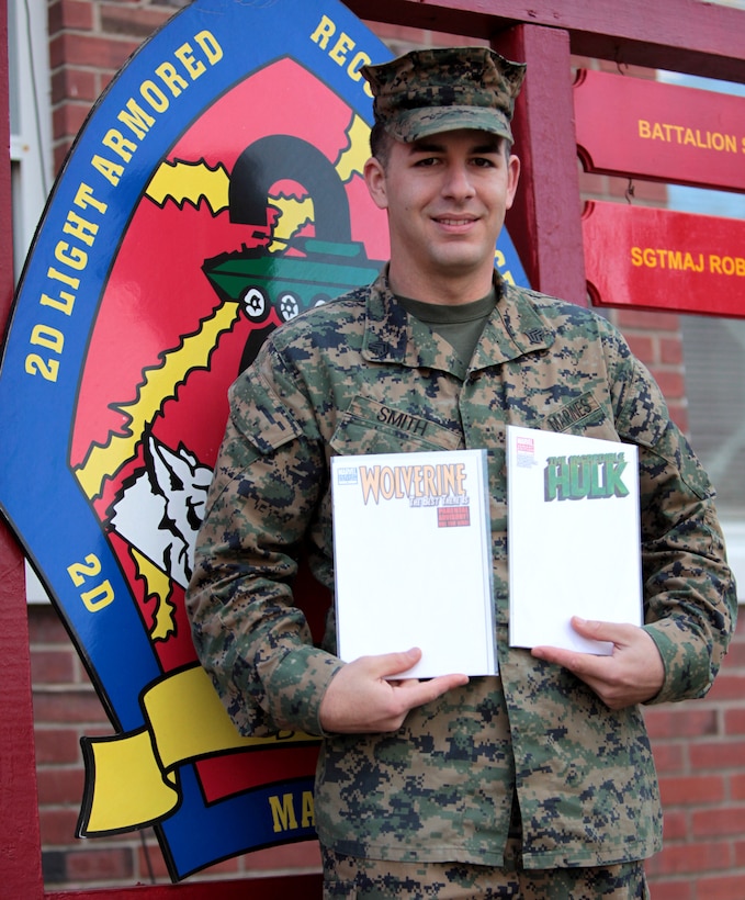 Sgt. Jacob Smith, a scout squad leader with Headquarters and Service Company, 2nd Light Armored Reconnaissance Battalion and founder of Comics 4 Heroes, poses holding white covered Marvel Comic books in front of the LAR Battalion sign aboard Marine Corps Base Camp Lejeune, N.C., Dec. 19. Depending on how well the auction goes, Smith says he would like to make Comics 4 Heroes a yearly event.