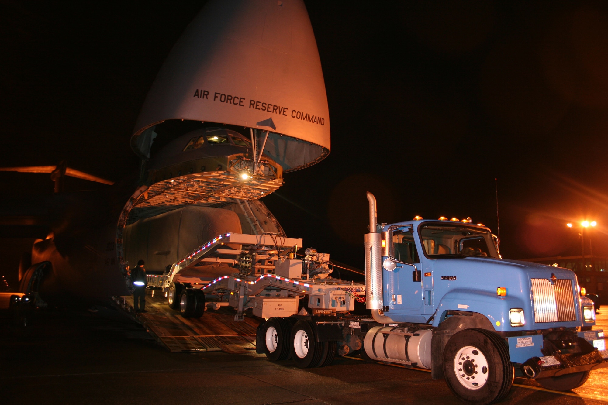 A Navy semi-trailer creeps up the ramps onto the 445th Airlift Wing's C-5 aircraft to transport the Advance SEAL Delivery System (ASDS), a type of Navy submarine, from McChord AFB, Wash., to its final destination, Pearl Harbor, Dec. 12, 2007.  The weight of the cargo tips the scales for the wing's heaviest move.  (U.S. Air Force photo/Mary Allen)  