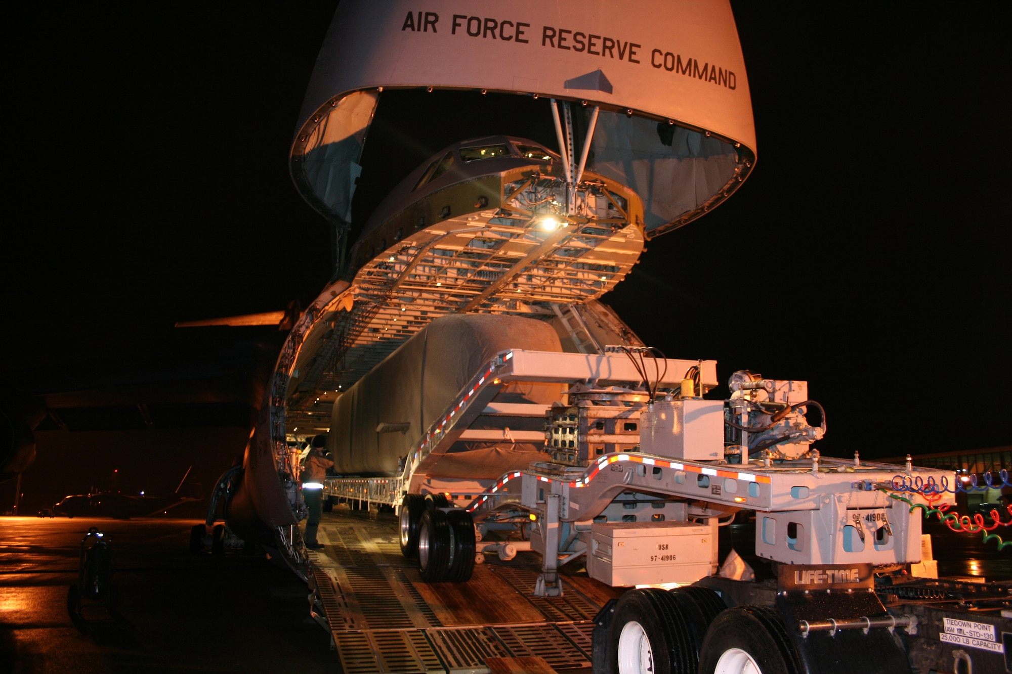 A Navy semi-trailer creeps up the ramps onto the 445th Airlift Wing's C-5 aircraft to transport the Advance SEAL Delivery System (ASDS), a type of Navy submarine, from McChord AFB, Wash., to its final destination, Pearl Harbor, Dec. 12, 2007.  The weight of the cargo tips the scales for the wing's heaviest move. (U.S. Air Force photo/Mary Allen)  