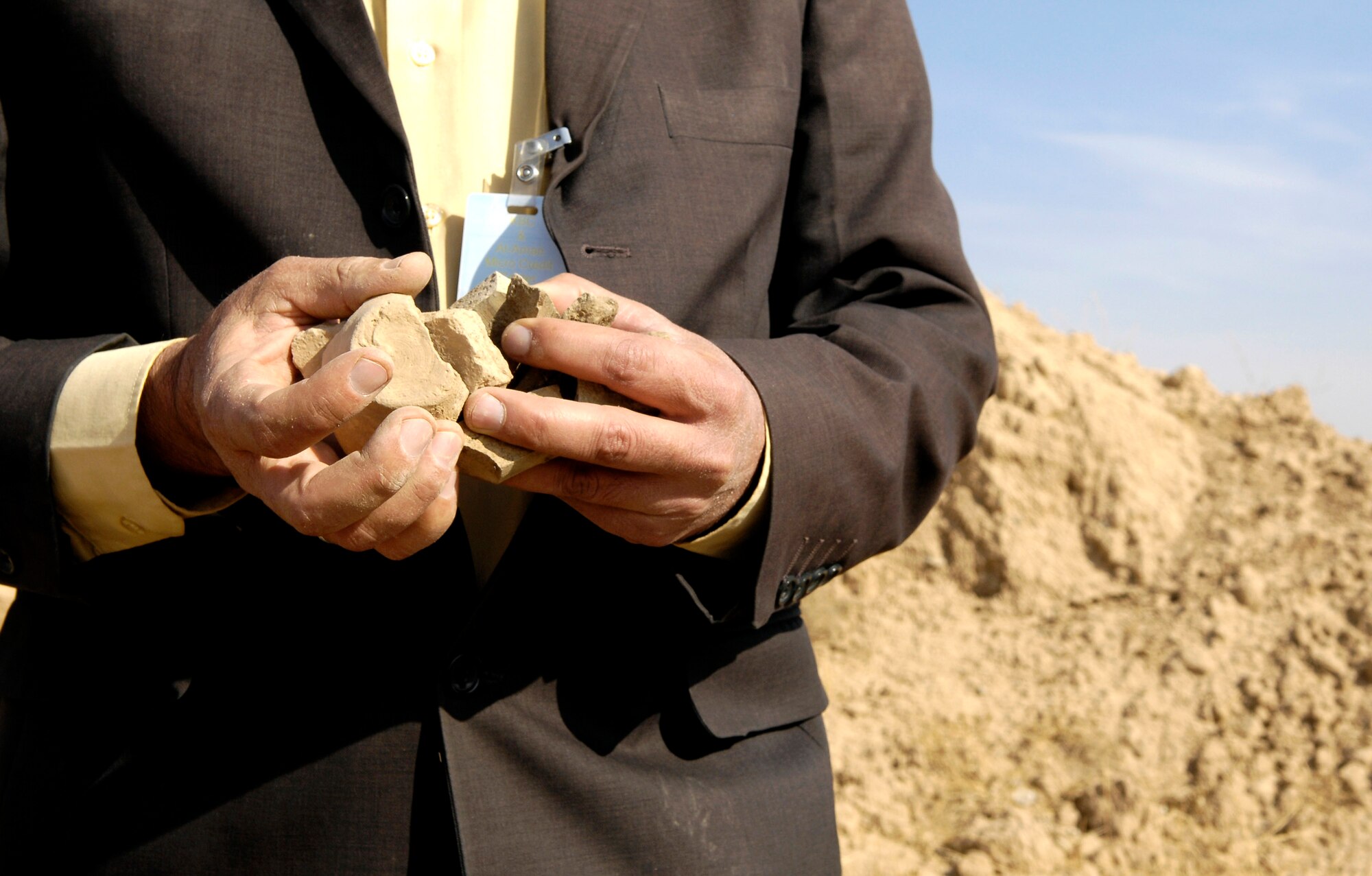 Iraqi archeologist S.M. Ameen holds some pottery artifacts he found Dec. 26 at one of four Kirkuk Air Base, Iraq, construction sites. Artifacts were first discovered by civil engineering Airmen while grading an area near the flightline. Mr. Ameen is the assistant curator at the Kirkuk Museum. (U.S. Air Force photo/Staff Sgt. Brian Ferguson)