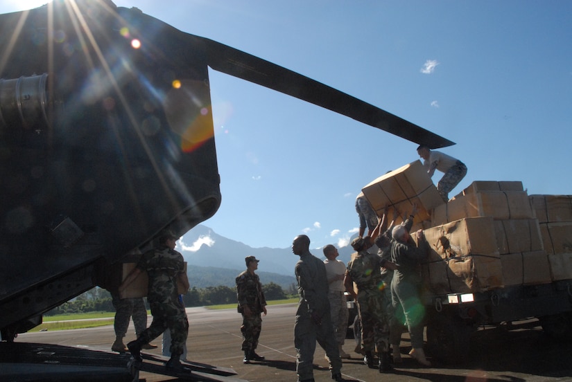 LA CEIBA, Honduras - Soldiers and Airmen from Joint Task Force-Bravo at Soto Cano Air Base, Honduras, offload donated wheelchairs from a CH-47 Chinook helicopter here Dec. 28.  The hand-crank wheelchairs were donated to isolated villages along the Miskito Coast of Honduras.  The Alabama non-profit organization Missions Unlimited contacted the U.S. Agency for International Development to coordinate the donation. (U.S. Air Force photo by Tech. Sgt. Sonny Cohrs) 