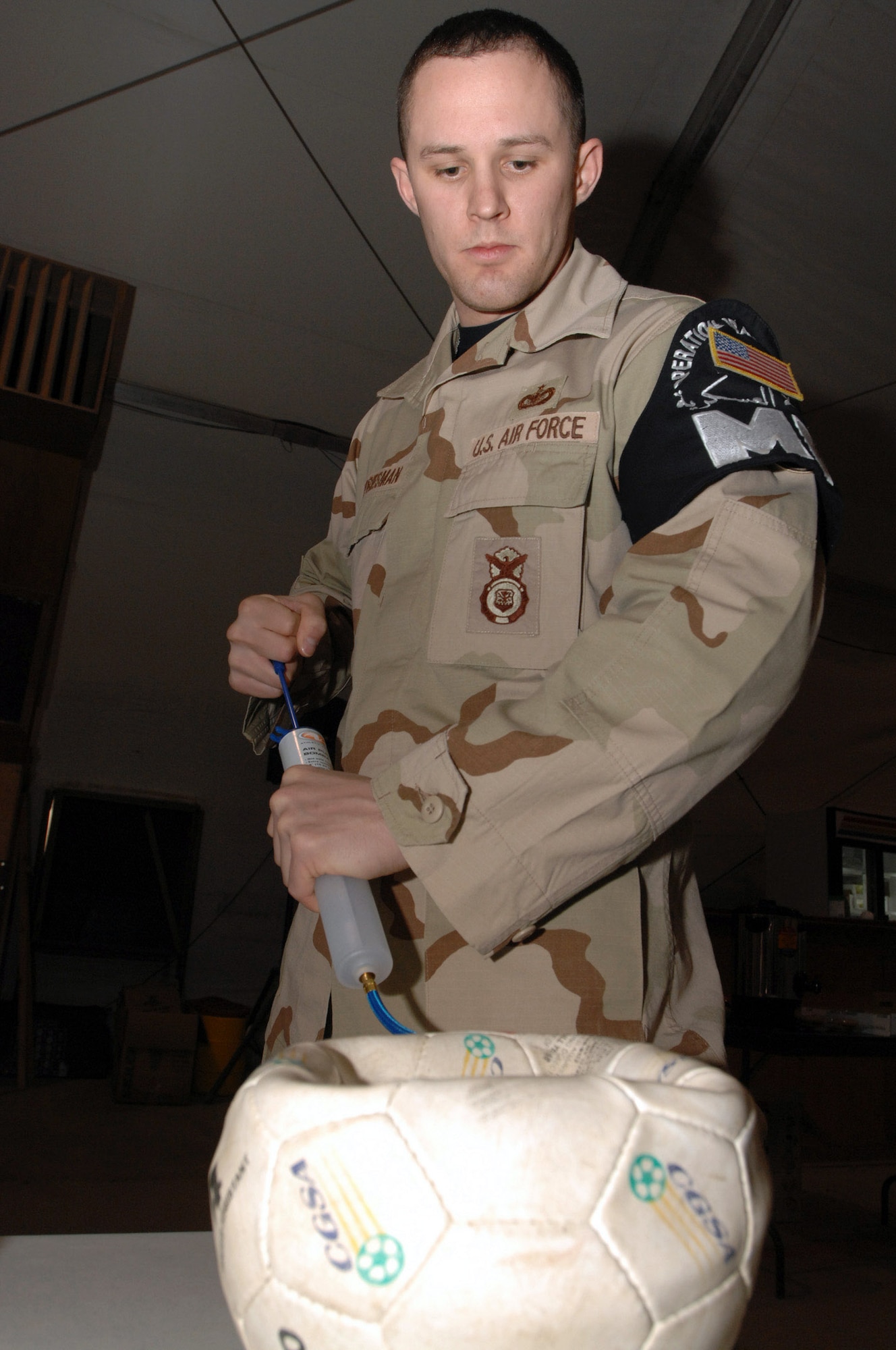 Staff Sgt. Daniel Priesman inflates a soccer ball at Ali Base, Iraq, Dec. 22 in support of Operation Iraqi Child. In just over a month, Airmen on base collected thousands of school supply items, toys and clothing from friends and family in the U.S. The donated items will be given to Iraqi families in the An Nasiriyah area. Sergeant Priesman is assigned to the 407th Expeditionary Provost Marshal Office and is deployed from Royal Air Force Lakenheath, England. (U.S. Air Force photo/Airman 1st Class Jonathan Snyder) 