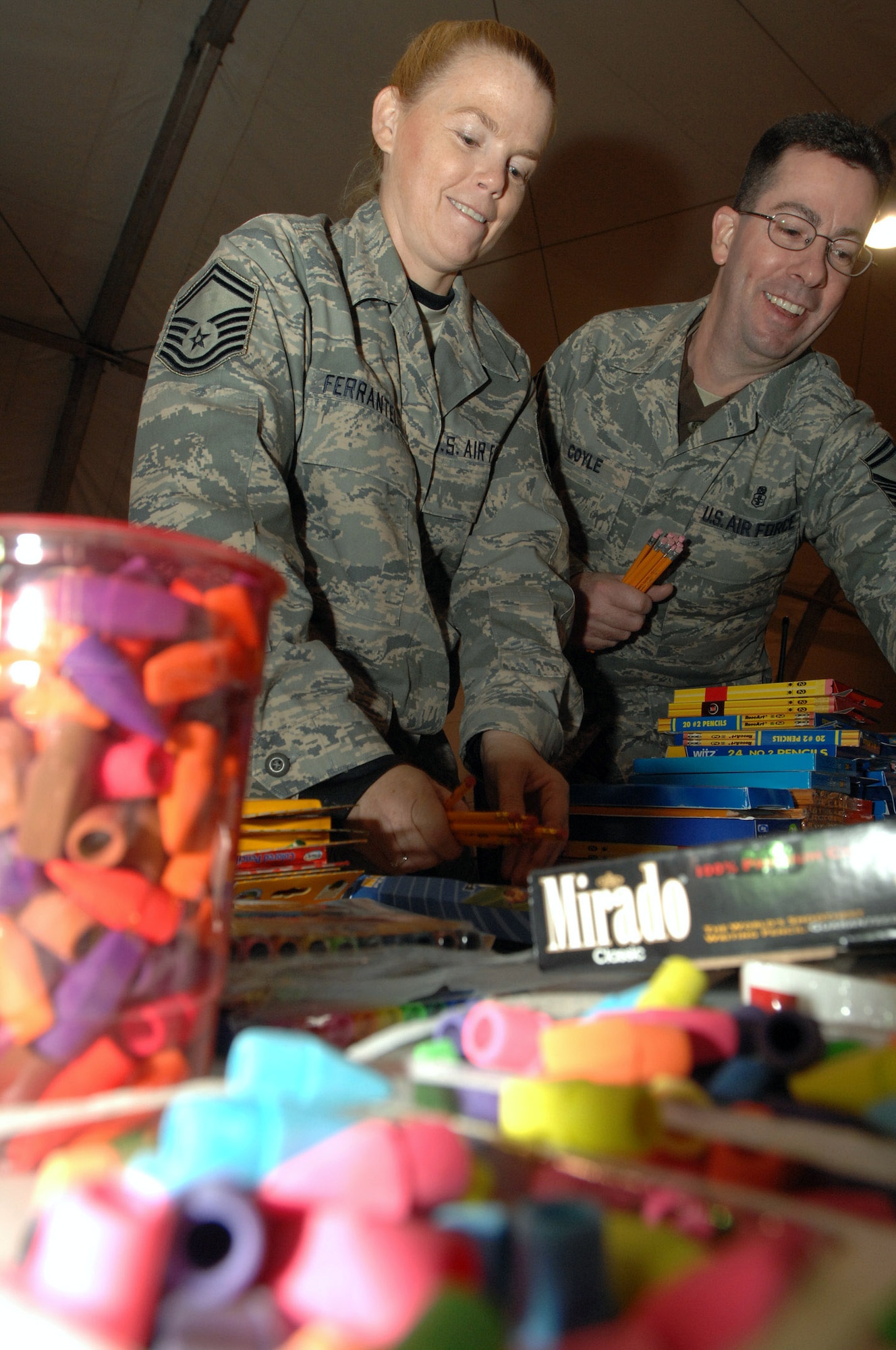 Master Sgt. Stephen Charles hands out school supplies in support of Operation Iraqi Child at Ali Base, Iraq, Dec. 22. In just over a month, Airmen on base collected thousands of school supply items, soccer balls, stuffed animals and toys from family and friends in the U.S. The donated items which will be given to Iraqi families in the An Nasiriyah area. The senior NCOs are assigned to the 407th Air Expeditionary Group. (U.S. Air Force photo/Airman 1st Class Jonathan Snyder) 
