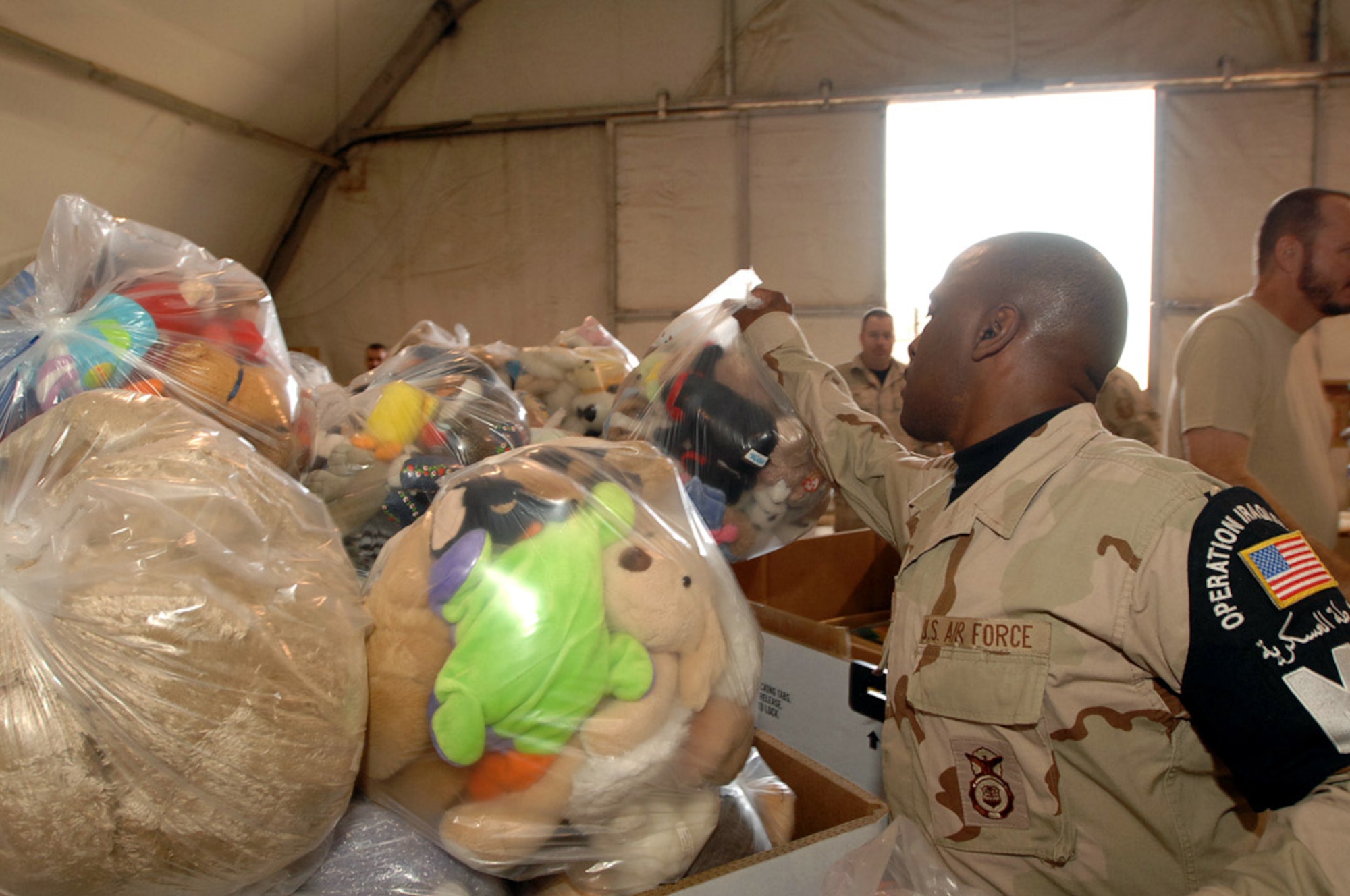 Tech. Sgt. Paul Wright tosses a bag of toys into a crate filled with even more toys at Ali Base, Iraq, Dec. 22. The donated items were collected by the 407th Air Expedtionary Airmen in support of Operation Iraqi Child. The donations will be given to Iraqi families in the An Nasiriyah area. Sergeant Wright is assigned to the 407th Expeditionary Provost Marshal Office and is deployed from Spangdahlem Air Base, Germany. (U.S. Air Force photo/Airman 1st Class Jonathan Snyder) 