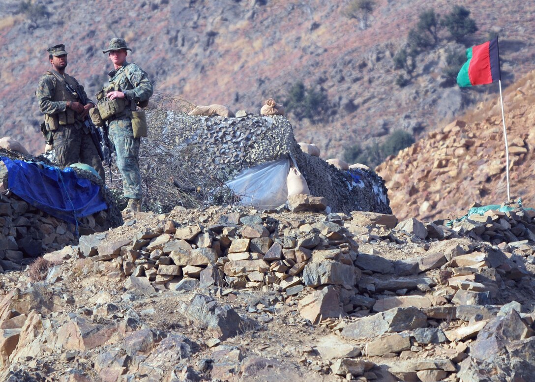 Marine Sgt. Seth E. Lewis (left) of Chattanooga, Tenn., and Marine 1st Sgt. Matthew S. Seamans, of Shorewood, Minn., stand at an observation point on top of a mountain and look over a border checkpoint 500 meters below. Lewis and Seamans are embedded training team mentors deployed to Afghanistan from Okinawa, Japan, to work with the Afghan National Army. Photo by Marine Staff Sgt. Luis P. Valdespino Jr.