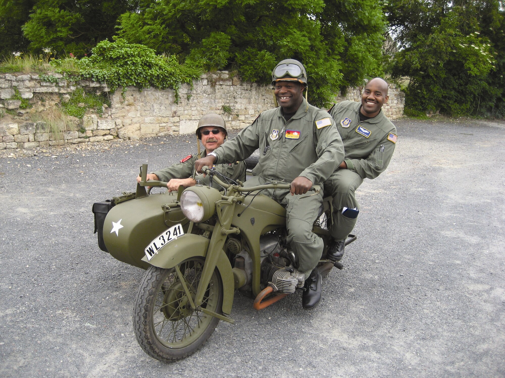 Lt. Col. Keith Guillotte (from left) pilot, Staff Sgt. Winston Demmin, crew chief, and Master Sgt. Sebastian Faison, loadmaster, all from the 729th Airlift Squadron, get into character as they have a seat on a period motorcycle. This was day one of their trip to Normandy, France this past June to support the flyovers of the Picauville American Memorial and the Normandy-American Cemetery. The crew said they were overwhelmed by the amazing number of French citizens who dressed like American Soldiers from the D-Day period. The locals had also, over the many years since the war, refurbished an abundant amount of reclaimed U.S. military vehicles – jeeps, tanks, motorcycles, etc. (U.S. Air Force photo)