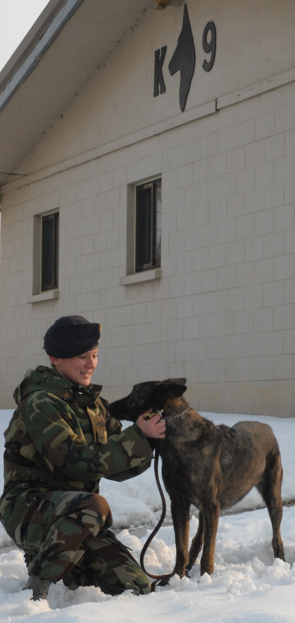 KUNSAN AIR BASE, South Korea -- Senior Airman Rachel Sarcia takes a break with her partner, Archie, at the newly renovated military working dog facility here Dec. 28.  Airman Sarcia and members of the 8th Security Forces Squadron K-9 unit train and work side-by-side with K-9s as part of their duties.  (U.S. Air Force photo / Senior Airman Steven R. Doty)
