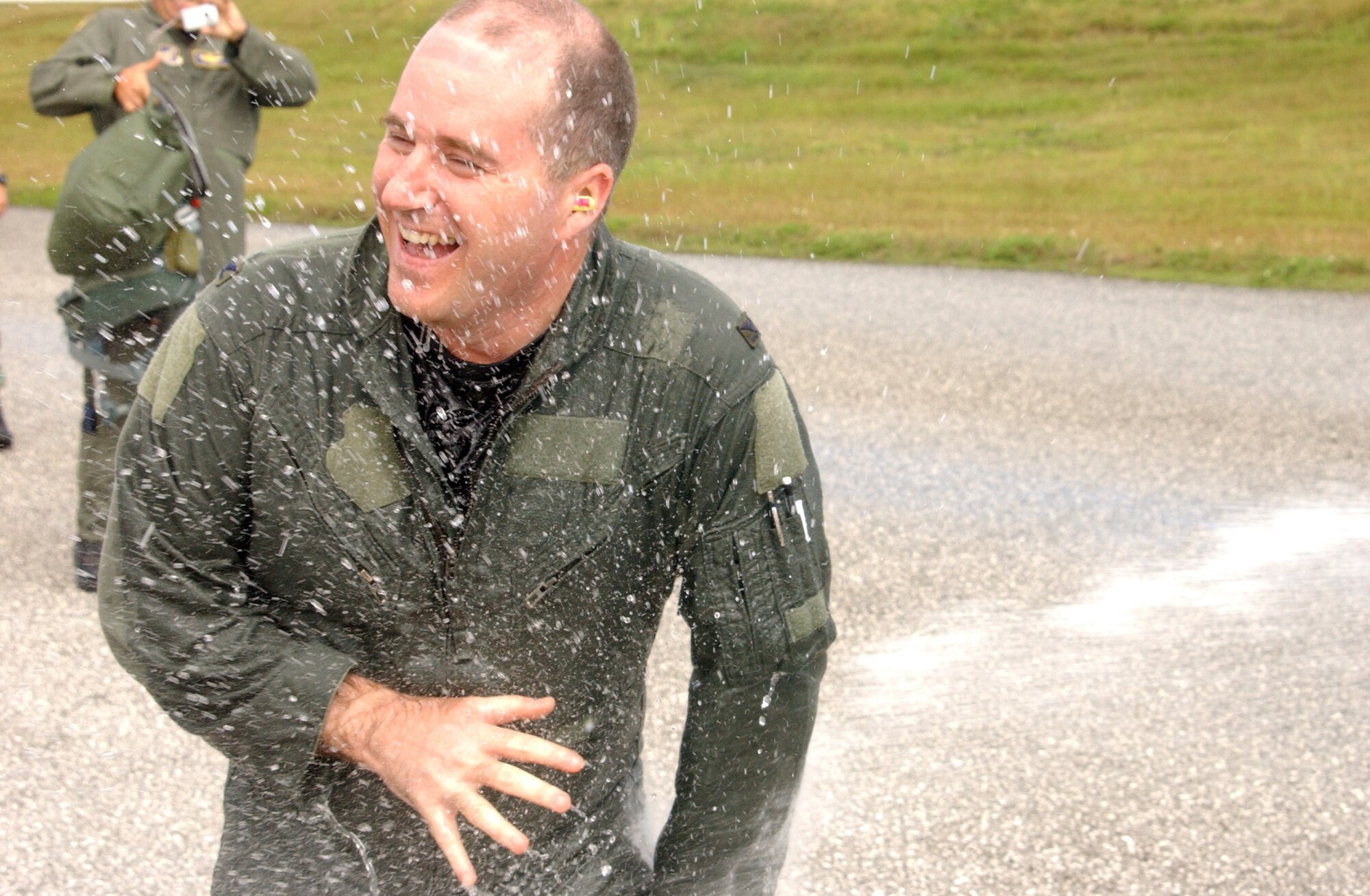 Col. Damian McCarthy, 36th Operations Group commander, receives incoming fire from a fire hose held by his wife, Jennifer. Colonel McCarthy flew in the B-2 Spirit stealth bomber here January 3 and was only the 409th person to ever fly the aircraft, a number which he will own forever. A unique facet of the stealth bomber aviation community is when someone actually flies in the aircraft; they are issued a number that numerically documents their having flown in the jet. The next person who rides in a stealth bomber will be issued number 410. Other individuals that “own” numbers documenting their ride in America’s most lethal and advanced bomber are Representative Ike Skelton and The History Channel’s R. Lee Ermey.  (Air Force photo/Tech. Sgt. Steven Wilson)