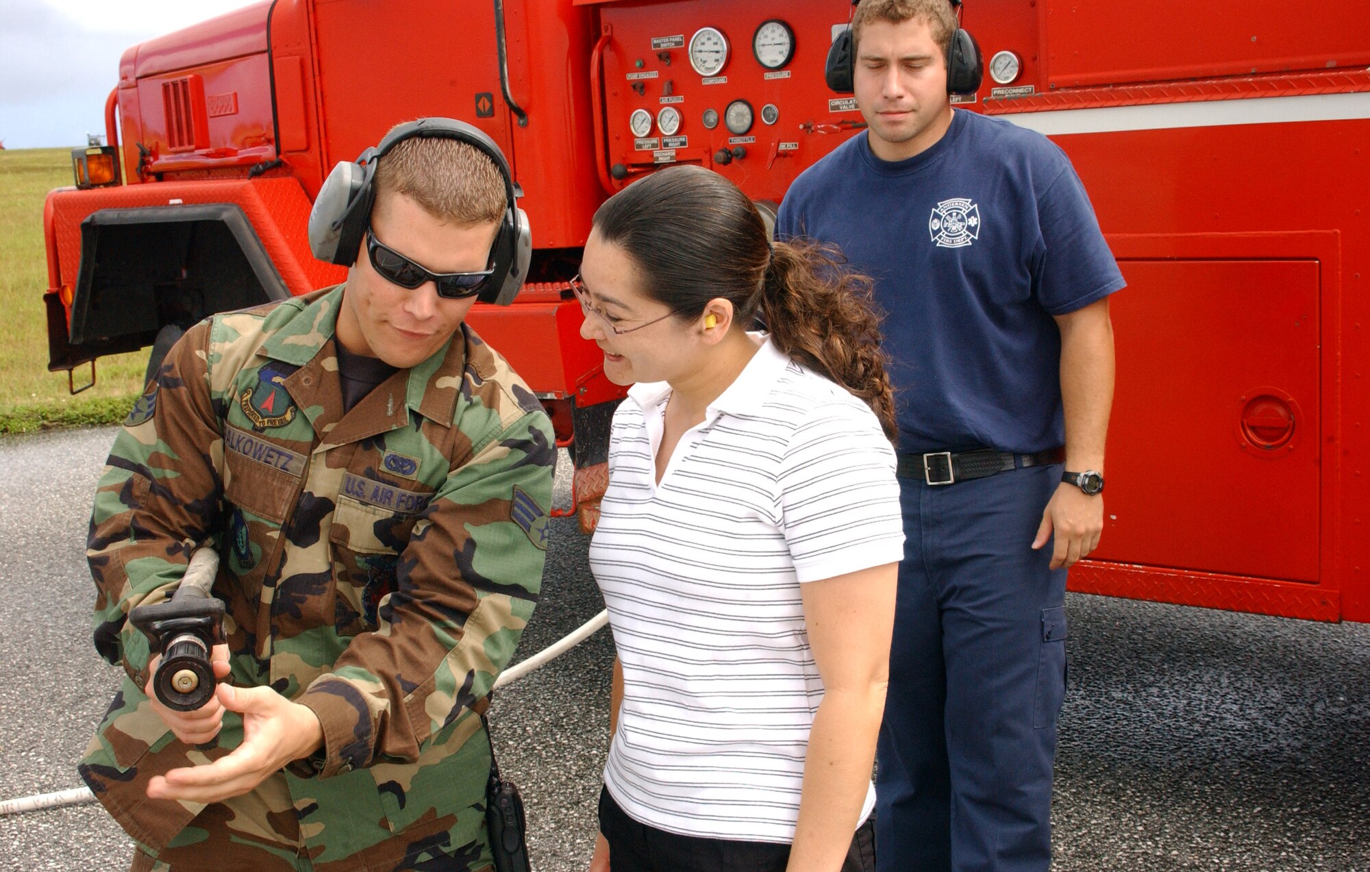 Mrs. Jennifer McCarthy receives operating instructions from firefighter Senior Airman Christopher Palkowetz as she waits for her husband, Col. Damian McCarthy, 36th Operations Group commander to exit the B-2 Spirit that has just landed and taxied to the parking ramp. In keeping with B-2 tradition, Colonel McCarthy will taste the blast of an Air Force fire truck’s fire hose after his first flight in the stealth bomber. (Air Force photo/Tech. Sgt. Steven Wilson)