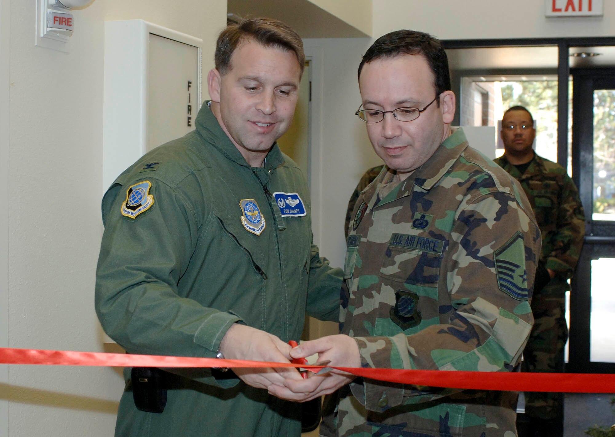 FAIRCHILD AIR FORCE BASE, Wash. – Col. Thomas Sharpy, 92nd Air Refueling Wing commander, and Master. Sgt Daniel Cartagena, 92nd Communication Squadron, cuts the ribbon for the reopening of the Airman’s Lounge on Dec. 21. The ceremony culminates an extensive six-week remodeling effort which features three 46- inch flat screen TV’s, gaming area and cyber café . (U.S. Air Force photo /Staff Sgt. JT May III)