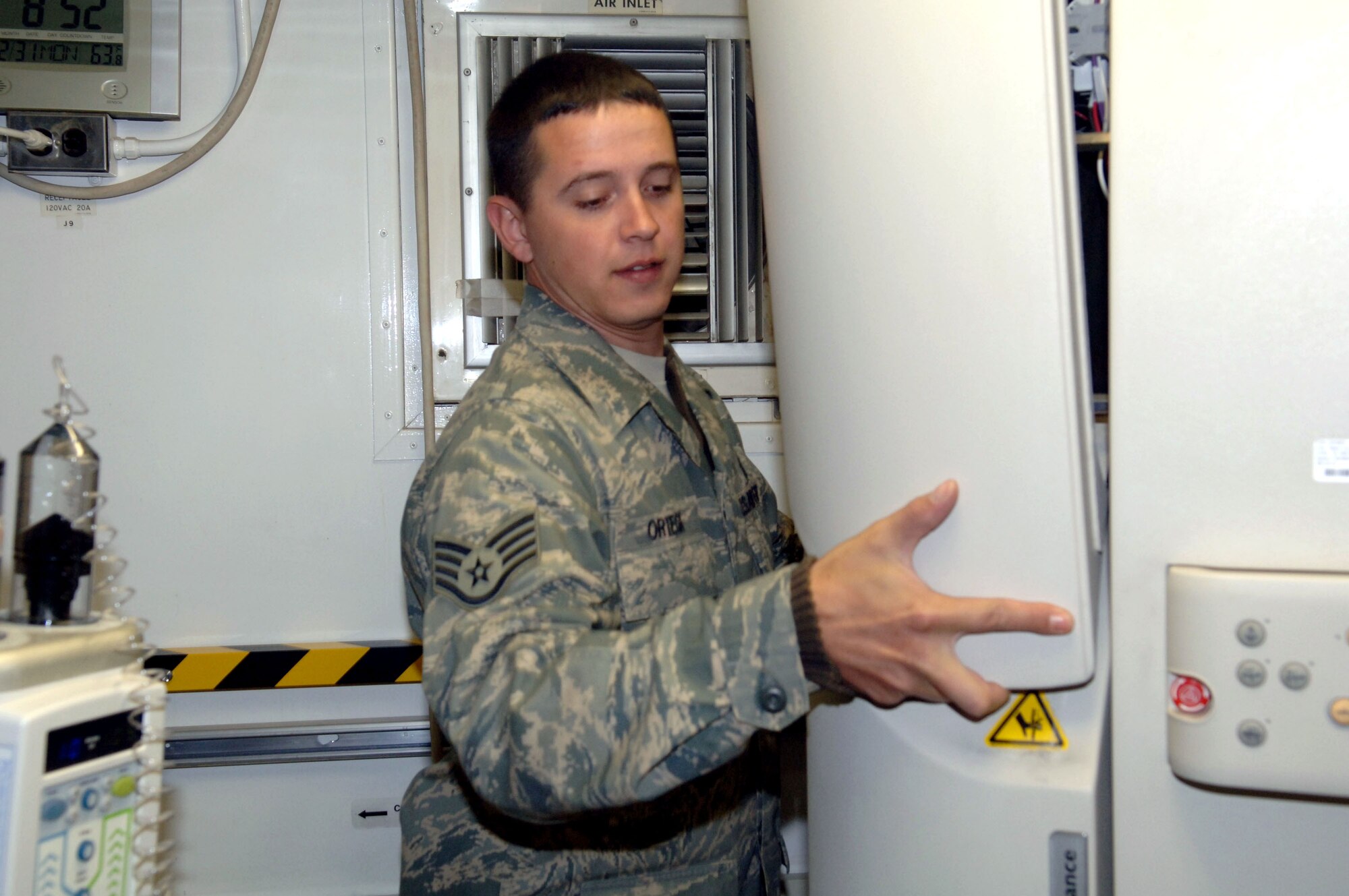 Staff Sgt. Orlando Ortega uses an allen wrench to loosen screws on the gantry cover of a computerized tomography machine Dec. 31 at the Air Force Theater Hospital at Balad Air Base, Iraq. Sergeant Ortega is a 332nd Expeditionary Medical Support Squadron biomedical equipment technician deployed from Barksdale Air Force Base, La. (U.S. Air Force photo/Senior Airman Terri Barriere)