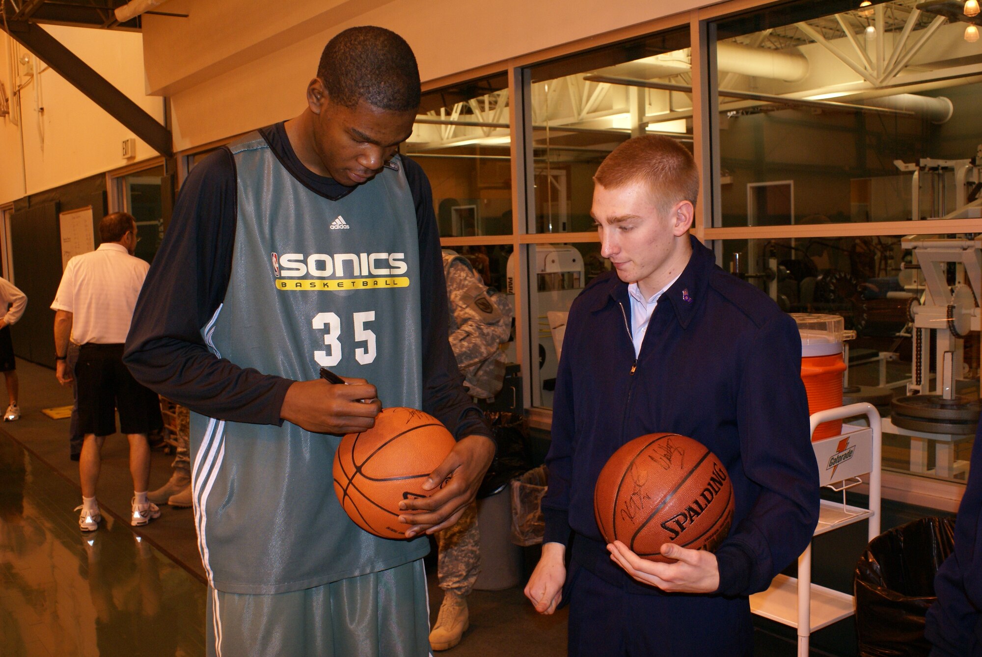 Seattle SuperSonics rookie Kevin Durant signs a basketball for Senior Airman Troy Bame, 62nd Operations Support Squadron,Wednesday at the Sonics practice facility in Seattle. Four McChord Airmen and servicemembers from other branches of the militarywere invited to the facility to watch a practice, meet and eat lunch with the players, and attend Wednesday night’s gameagainst the New Orleans Hornets.