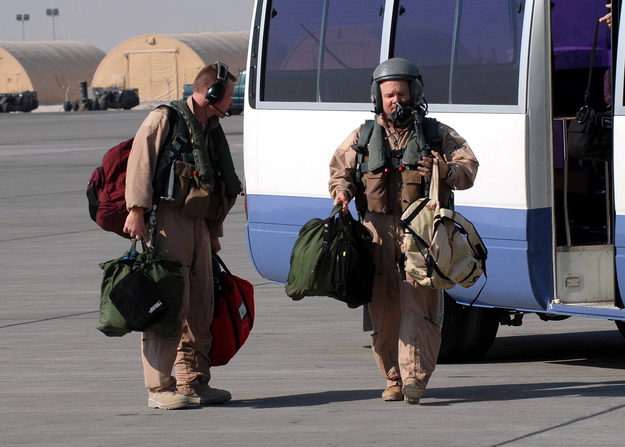 1st Lt. Thomas Walsh (left) and Brig. Gen. Charlie Lyon leave the crew bus Dec. 29 to board a B-1B Lancer bomber for a mission.  General Lyon is the 379th Air Expeditionary Wing commander and Lieutenant Walsh is an aircrew member with the 9th Expeditionary Bomb Squadron at an air base in Southwest Asia.  (U. S. Air Force photo/Staff Sgt. Douglas Olsen) 