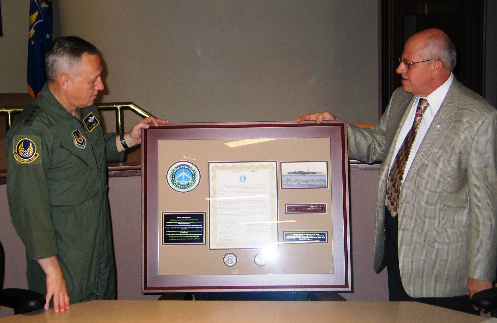 Tim Dues presents a plaque to Gen. Bruce Carlson to commemorate the Air Force's certification of Fischer-Tropsch fuel blends in the B-52H. Mr. Dues, the deputy director for maintenance within the Logistics Directorate at Headquarters Air Force Materiel Command, offered the plaque to General Carlson, the AFMC commander, on behalf of the B-52 Synthetic Fuel Initiative Team during a Dec. 21 meeting at Headquarters AFMC. (Air Force photo) 
 
