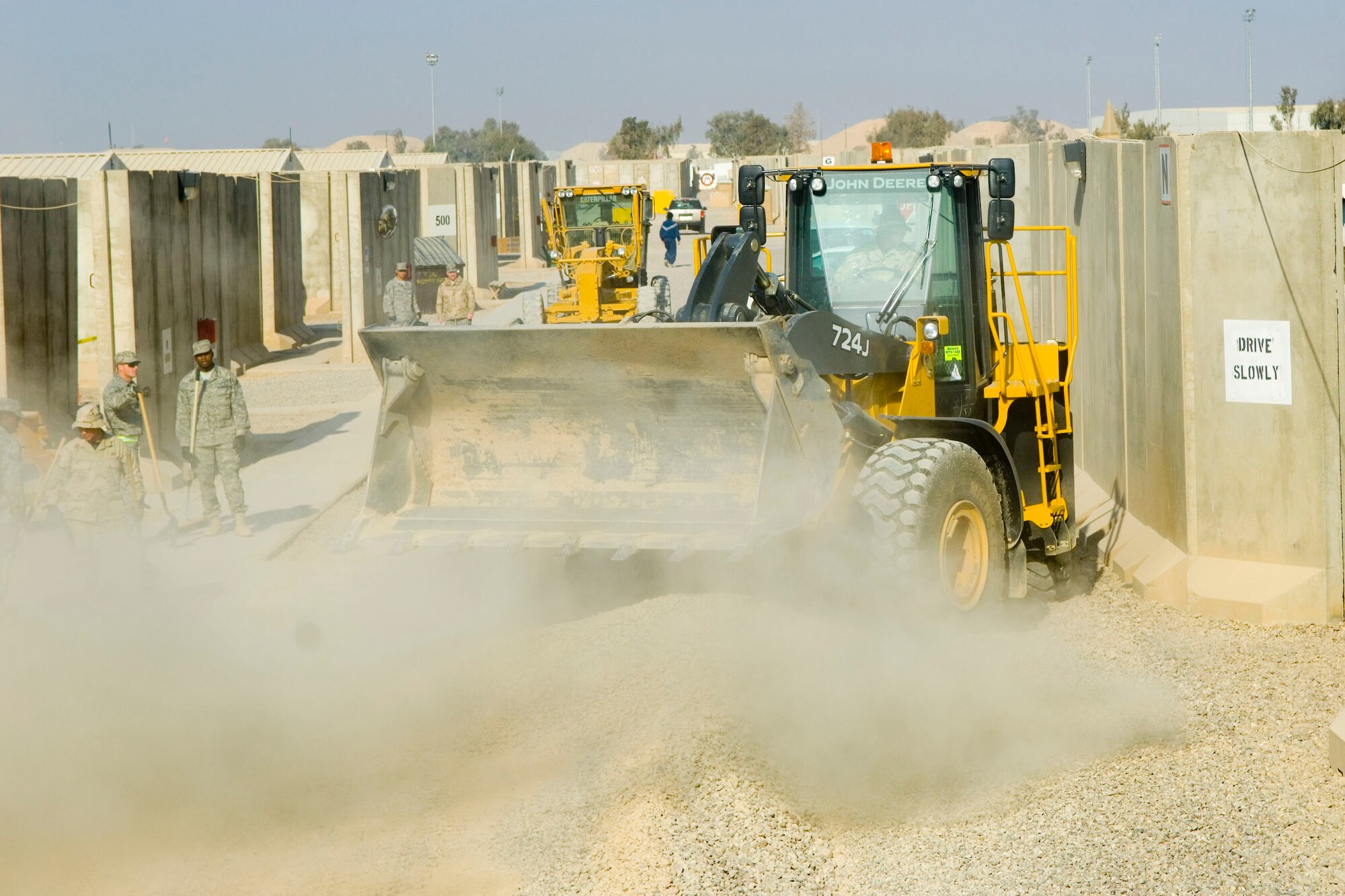 BALAD AIR BASE, Iraq -- Airman 1st Class Issac Turner, a 332nd Expeditionary Civil Engineer Squadron heavy equipment operator, maneuvers his loader to remove another batch of rocks and dirt from the Air Force housing area. The 332nd ECES was working in housing to create better drainage in preparation for mud season. Airman Turner is deployed from Spangdahlem Air Base, Germany. (U.S. Air Force photo /Staff Sgt. Travis Edwards)