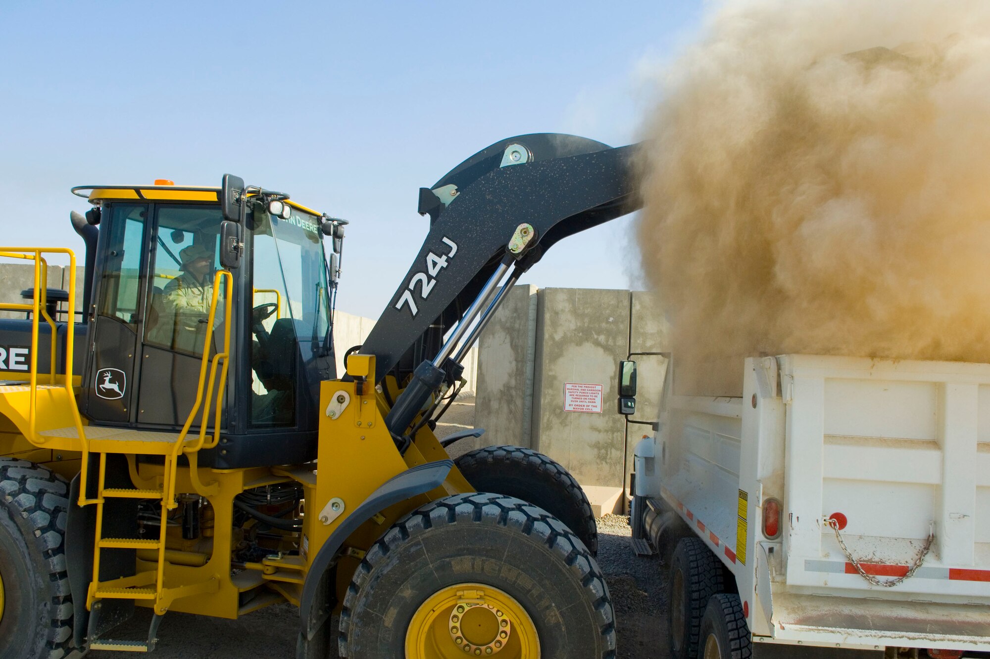 BALAD AIR BASE, Iraq -- Airman 1st Class Issac Turner, a 332nd Expeditionary Civil Engineer Squadron heavy equipment operator, loads rocks and dirt into a dump truck after working to prepare for mud season here, Dec. 3. Airman Turner is deployed from Spangdahlem Air Base, Germany. (U.S. Air Force photo /Staff Sgt. Travis Edwards)