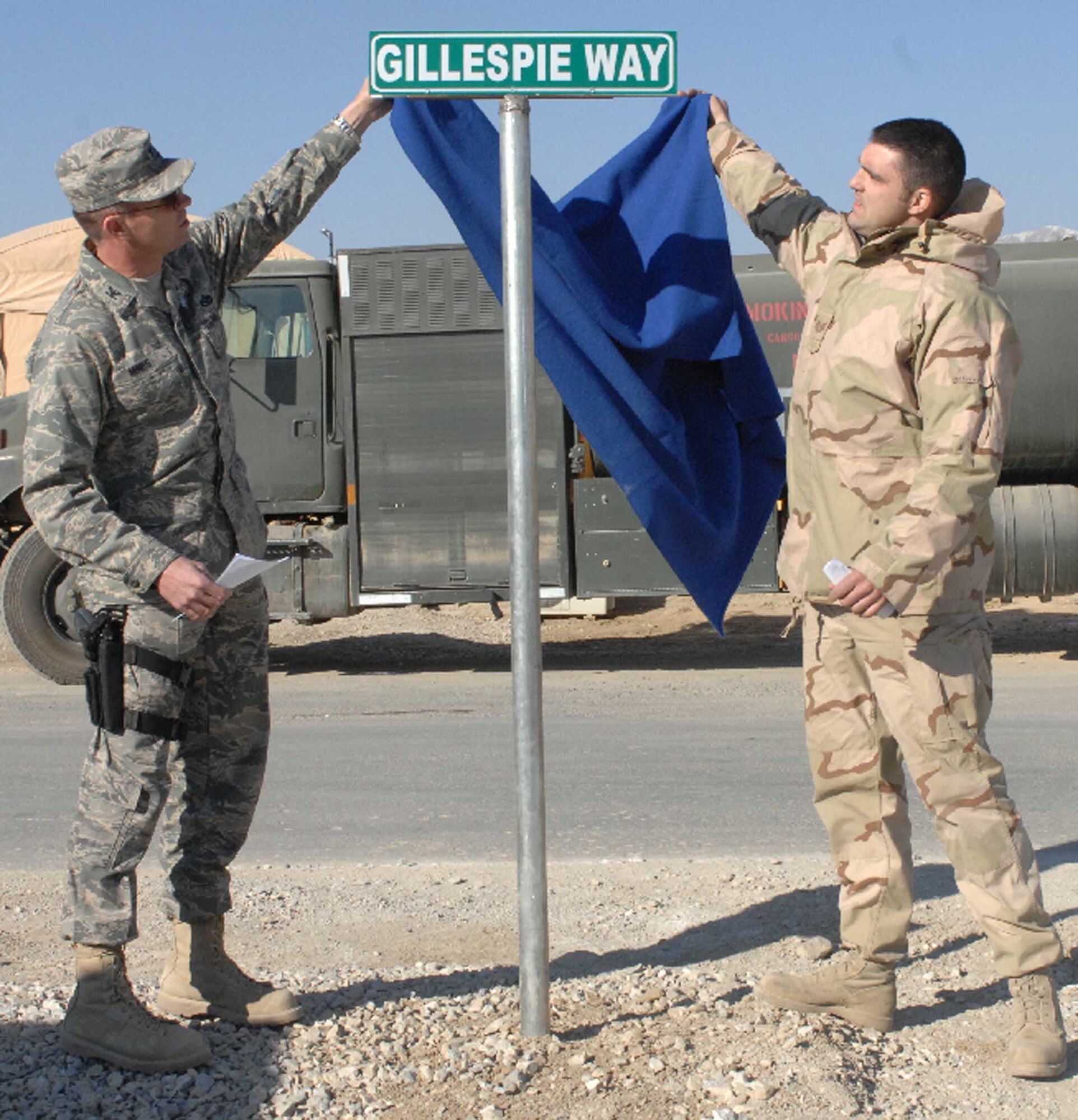 BAGRAM AIR BASE, Afghanistan - Col. Barry Mines (left), commander of the 455th Expeditionary Mission Support Group, and Tech. Sgt. Blaine Arsenault, 455th Expeditionary Logistics Readiness Squadron, unveil a sign dedicating a road here to the memory of fallen Airmen Master Sgt. Randy Gillespie, Jan. 1, 2008.  Sergeant Gillespie was a career fuels specialist who died July 9, 2007 from wounds sustained during small arms fire near Herat, Afghanistan. (U.S. Air Force Photo by Capt. Mike Meridith)