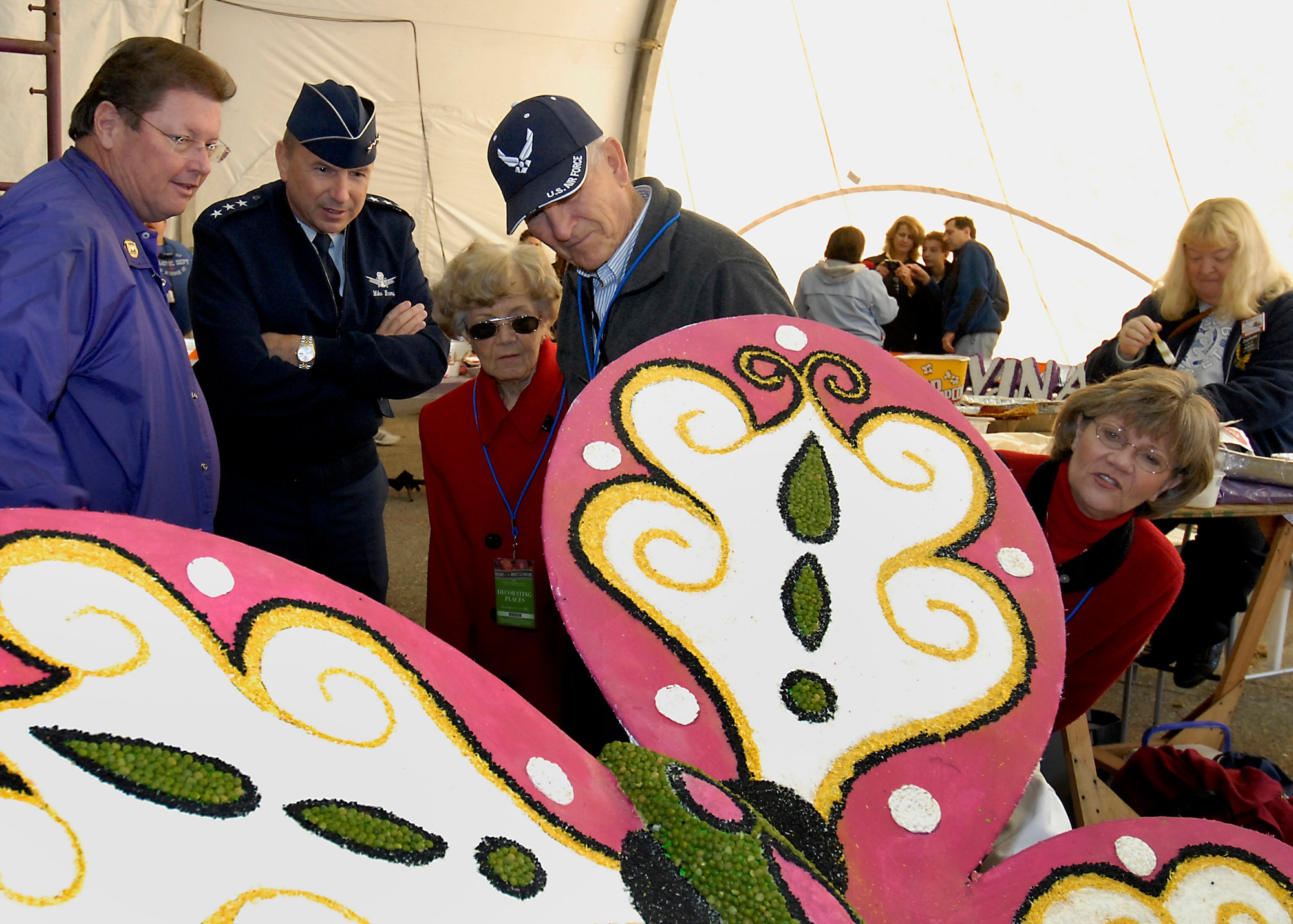 Lt. Gen. Michael Hamel, Space and Missile Systems Center commander (second from left), examines a huge floral butterfly on one of the Tournament of Roses Parade floats as a guide (left) explains its mechanics.  The general’s wife Linda (far right) checks it out from a different angle.  Mrs. Hamel’s parents retired Air Force Chief Master Sgt. Marlyn and Mrs. Lea Bonacker joined in on the tour of the float decoration area, Dec. 30.  (Photo by Joseph Juarez)