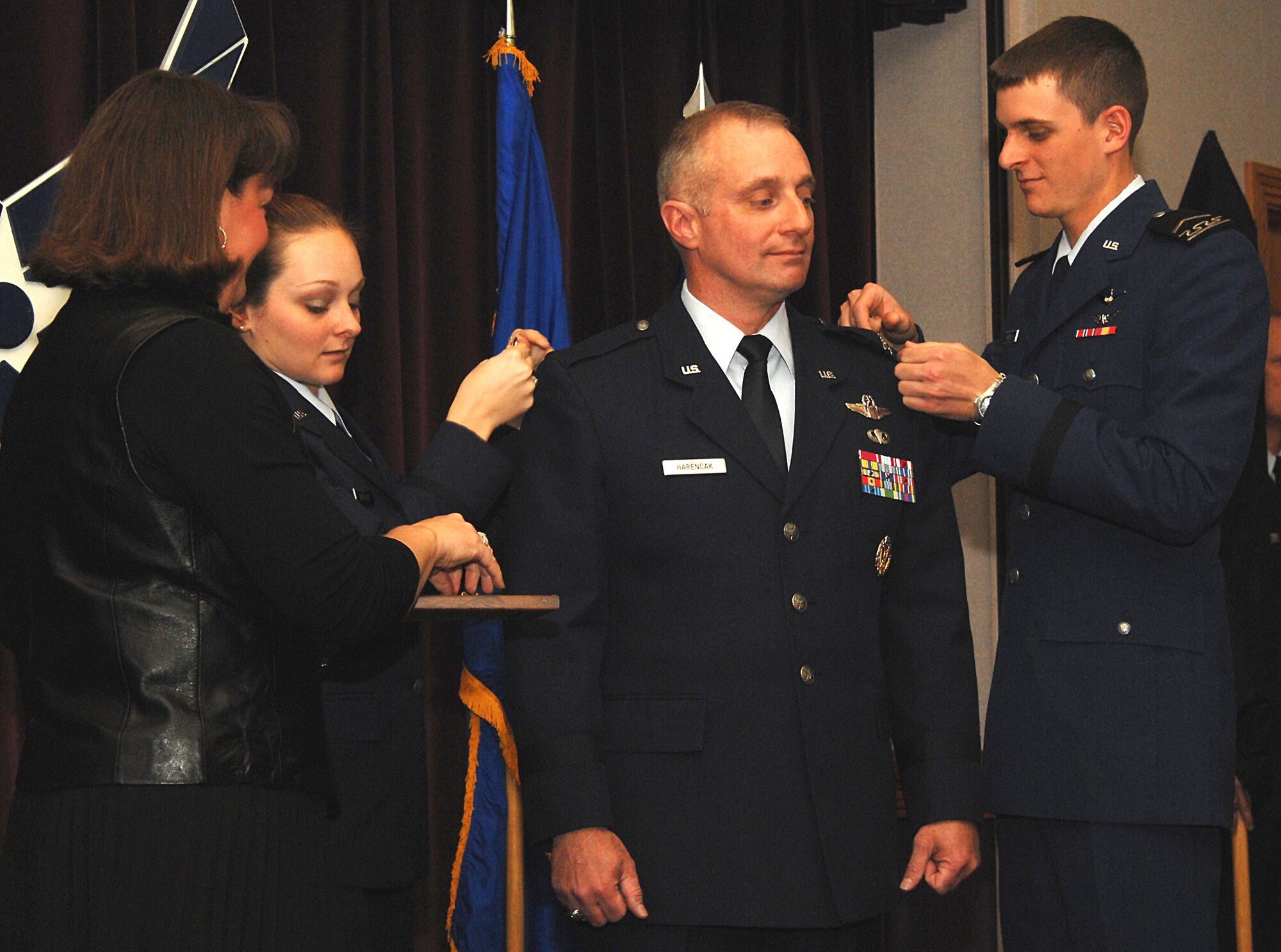 WHITEMAN AIR FORCE BASE, Mo. - Brig. Gen. Garrett Harencak, 509th Bomb Wing commander, watches his son, Cadet 3rd Class Michael Harencak pin a star on his uniform. His daughter, 2nd Lt. Megan Harencak, also pins on the new rank as his wife, Tanya Harencak looks on. General Harencak was officially promoted by retired Maj. Gen. Jack Catton Jr. in a ceremony here Jan. 4. (U.S. Air Force photo/Airman 1st Class Stephanie Clark)