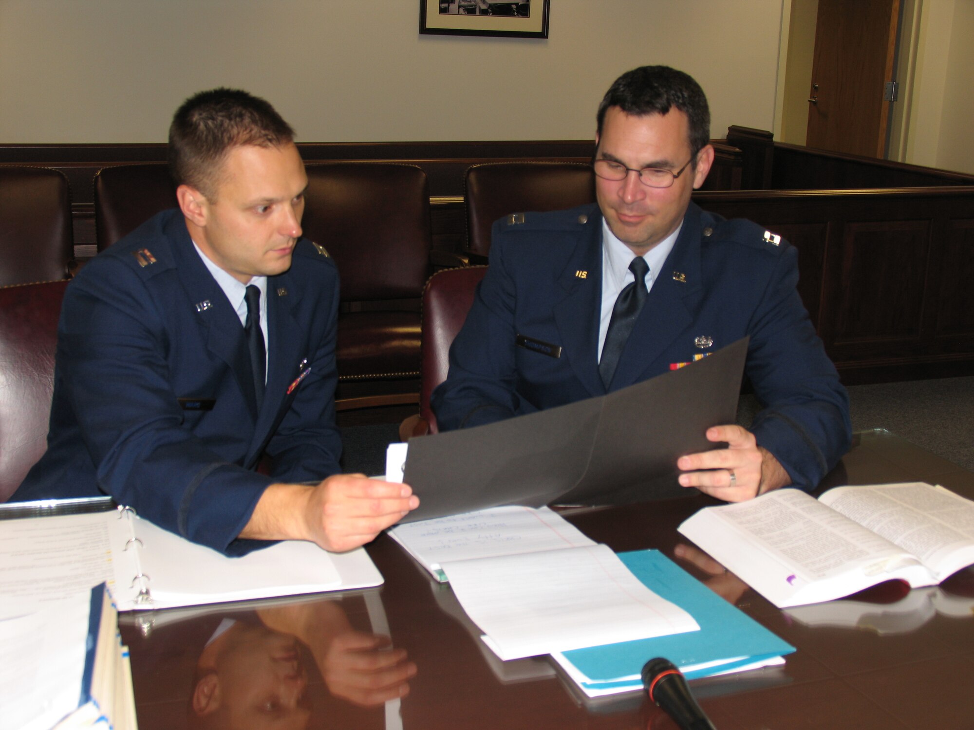 HANSCOM AFB, Mass. -- Capt. Tim Ward (left) and Capt. Chris Thompson, both assigned to the Electronic Systems Center Legal Office and appointed as Special Assistant U.S. Attorneys, review legal documents in the Hanscom Courtroom recently. As SAUSAs, the captains are able to prosecute federal and state criminal offenses before a Federal Magistrate Judge. (U.S. Air Force photo by 1st Lt. Lisa Spilinek.)