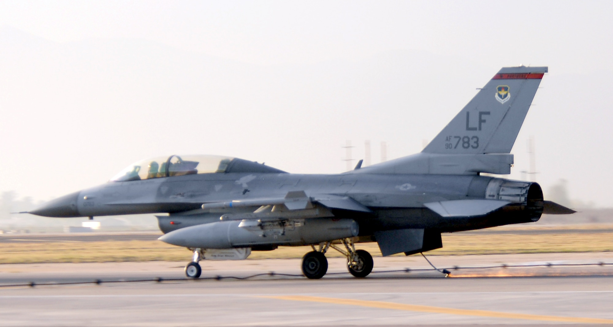 The tailhook of a 63rd Fighter Squadron F-16 scrapes along the runway before grabbing hold of the arresting barrier Dec 20. The barrier engagement is an annual requirement airfield managers must arrange and perform to ensure the systems are operational. (U.S. Air Force photo/Tech. Sgt. Raheem Moore)