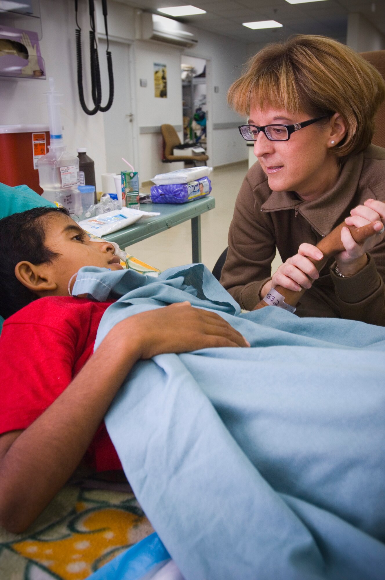 BALAD AIR BASE, Iraq -- Maj. Rebecca Cypher, an intermediate care ward nurse, provides a caring touch to a wounded Iraqi boy. Major Cypher provides ongoing care to patients who are recovering from injuries or less critical illnesses. She is deployed from Wilford hall Medical Center, San Antonio, Texas. (U.S. Air Force photo/Tech. Sgt. D. Clare)