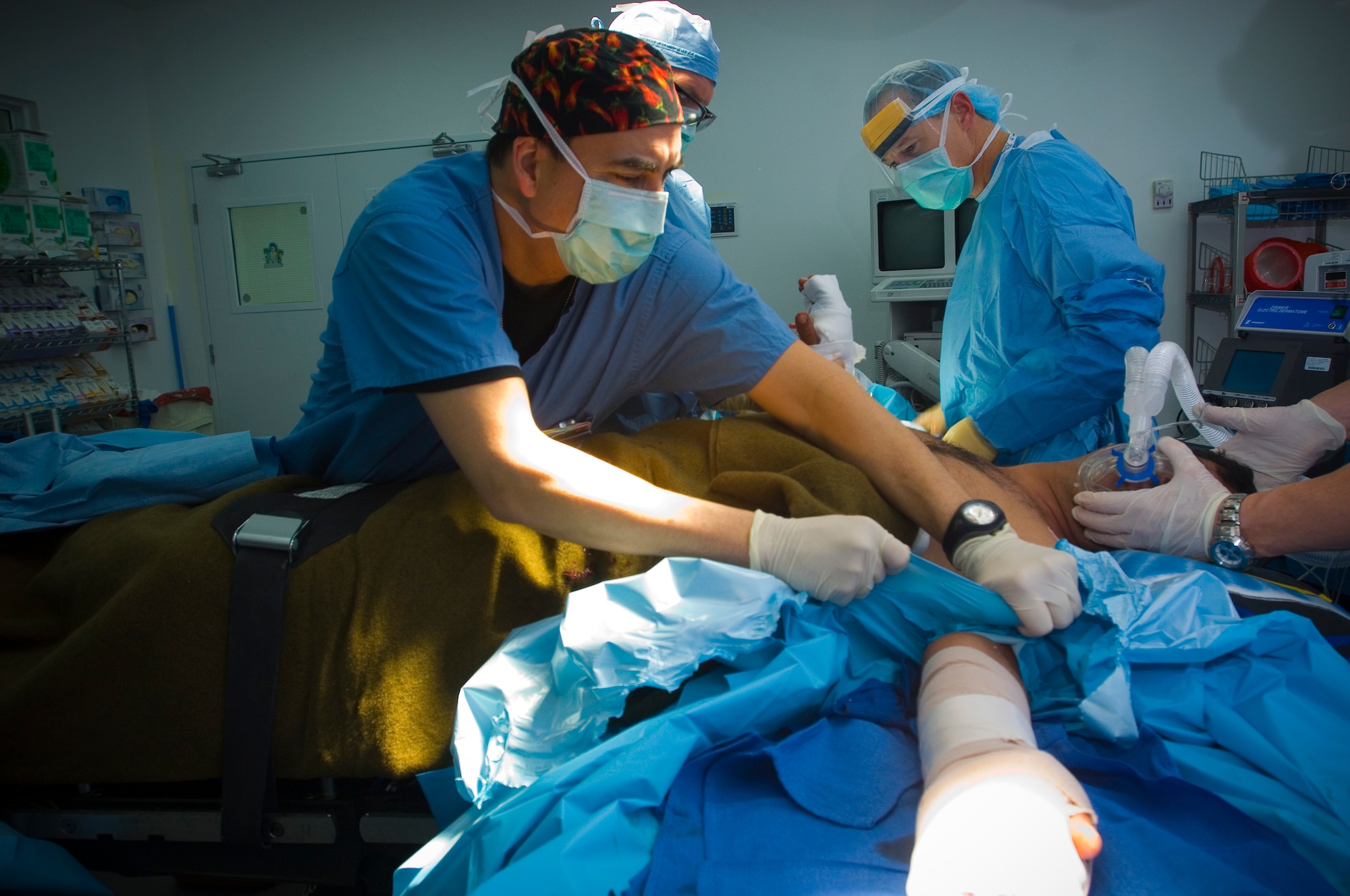 BALAD AIR BASE, Iraq -- Capt. George Moctezuma, an operating room nurse, removes a sterile field from a patient following a surgical procedure at the Air Force Theater Hospital here. Captain Moctezuma provides support to surgeons and technicians during operations to ensure they have the equipment they need and are able to safely perform procedures in a sterile environment. The captain is deployed from Wilford Hall Medical Center, San Antonio, Texas. (U.S. Air Force photo/Tech. Sgt. D. Clare)